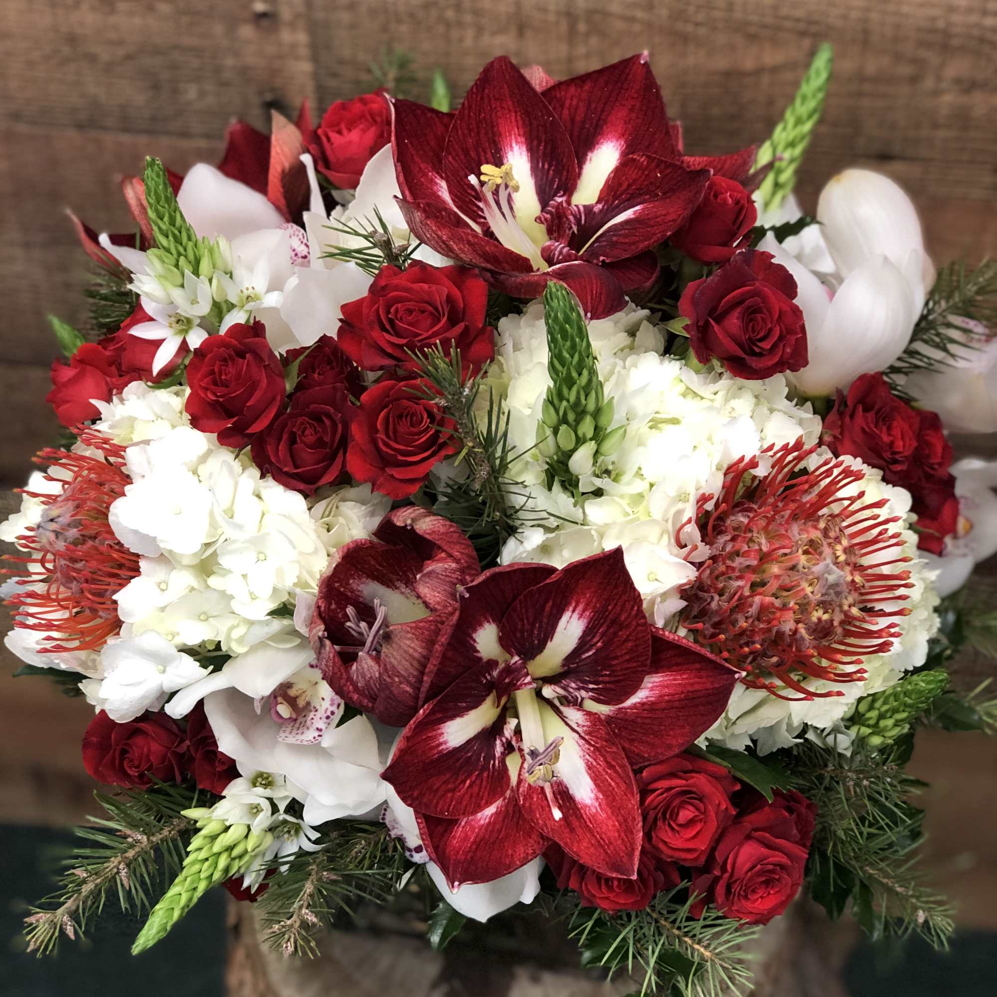 Bouquet of red roses, white blooms, and burgundy amaryllis