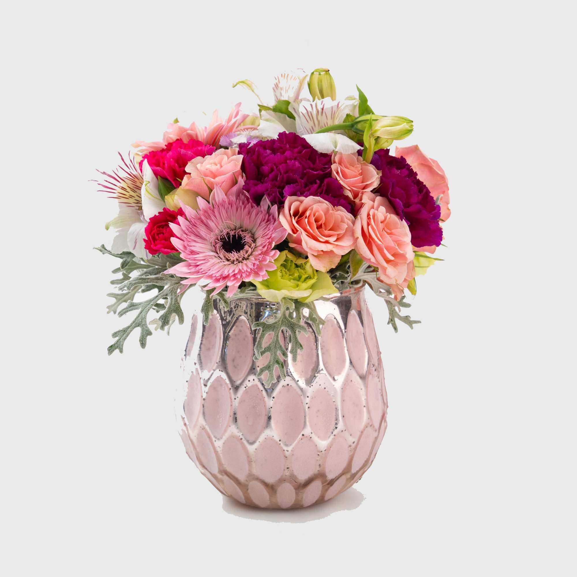 Mixed pink and peach flowers in a pink ceramic vase