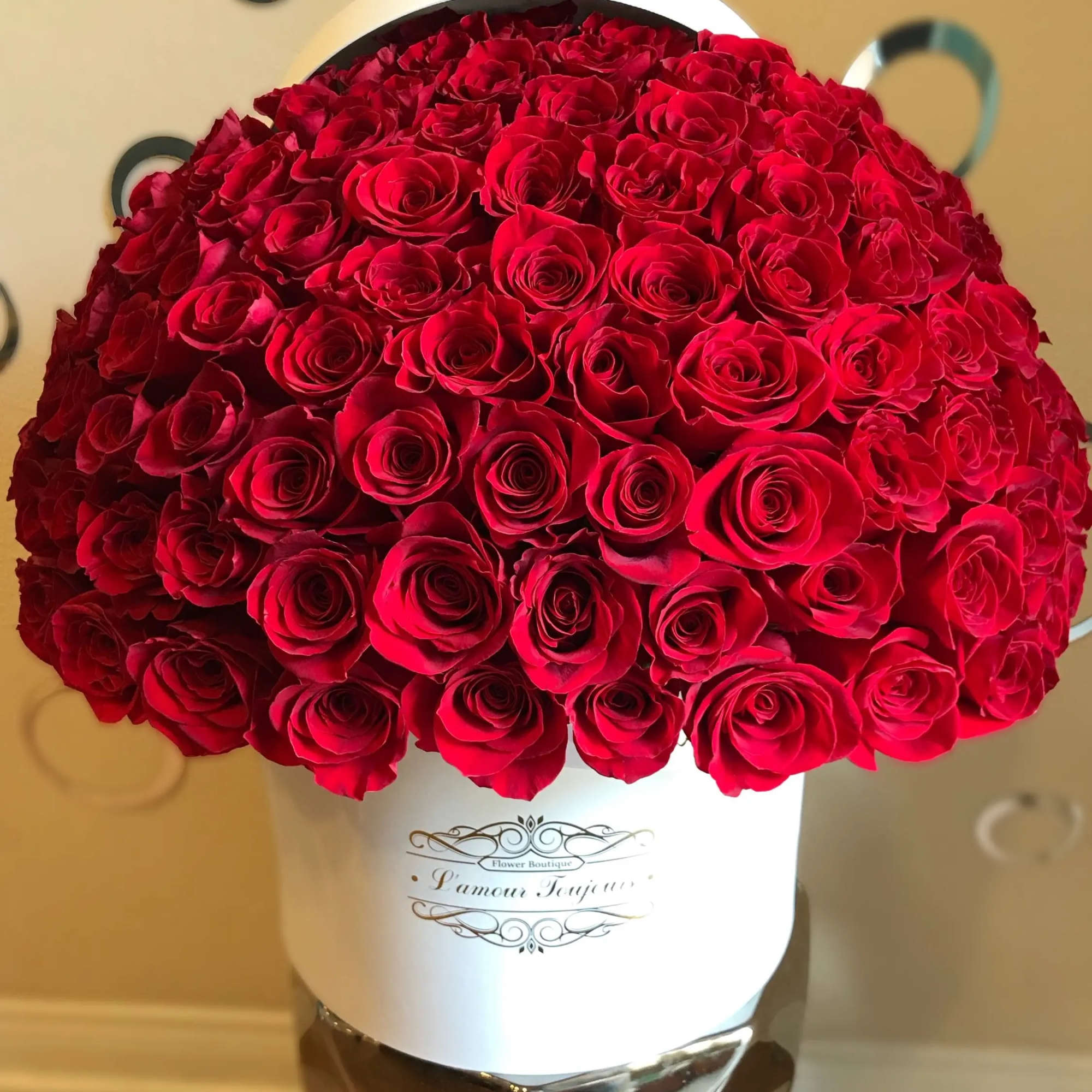 Large dome of red roses arranged in a white hatbox-style container.