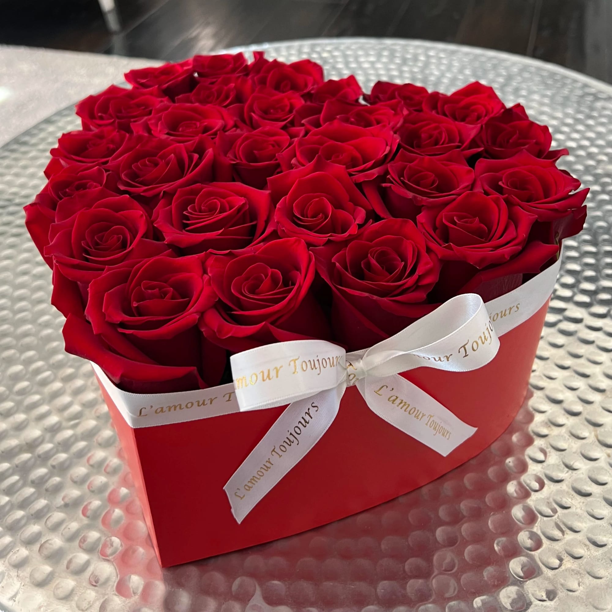 Heart-shaped red box filled with red roses and tied with a white ribbon, photo 2 of 3