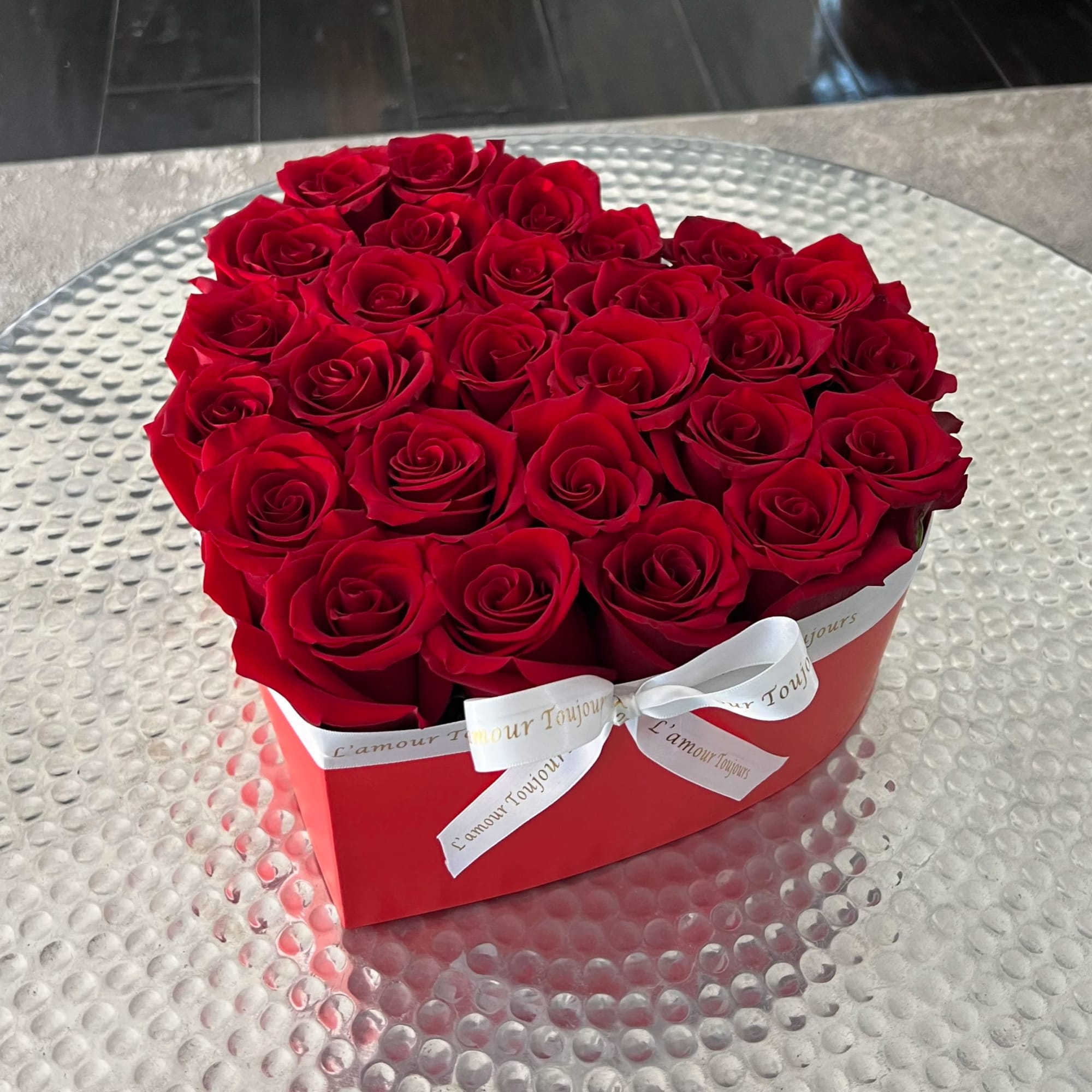 Heart-shaped red box filled with red roses and tied with a white ribbon, photo 3 of 3