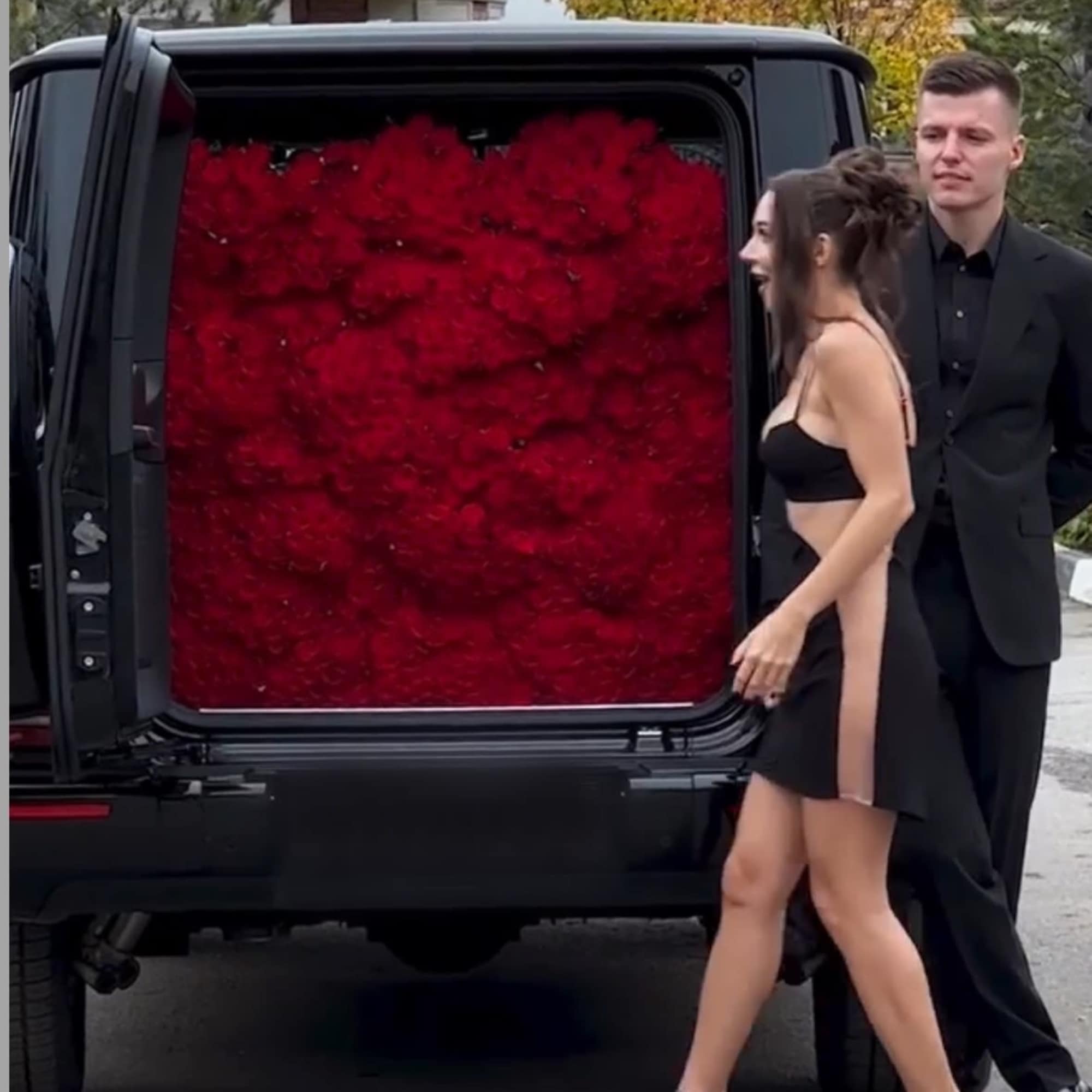 Black vehicle with a rear compartment filled with red flowers