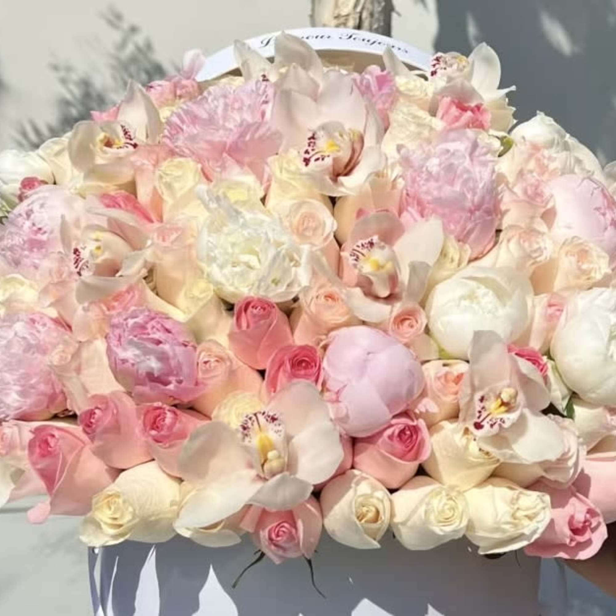 Large bouquet of pink and white roses with orchids