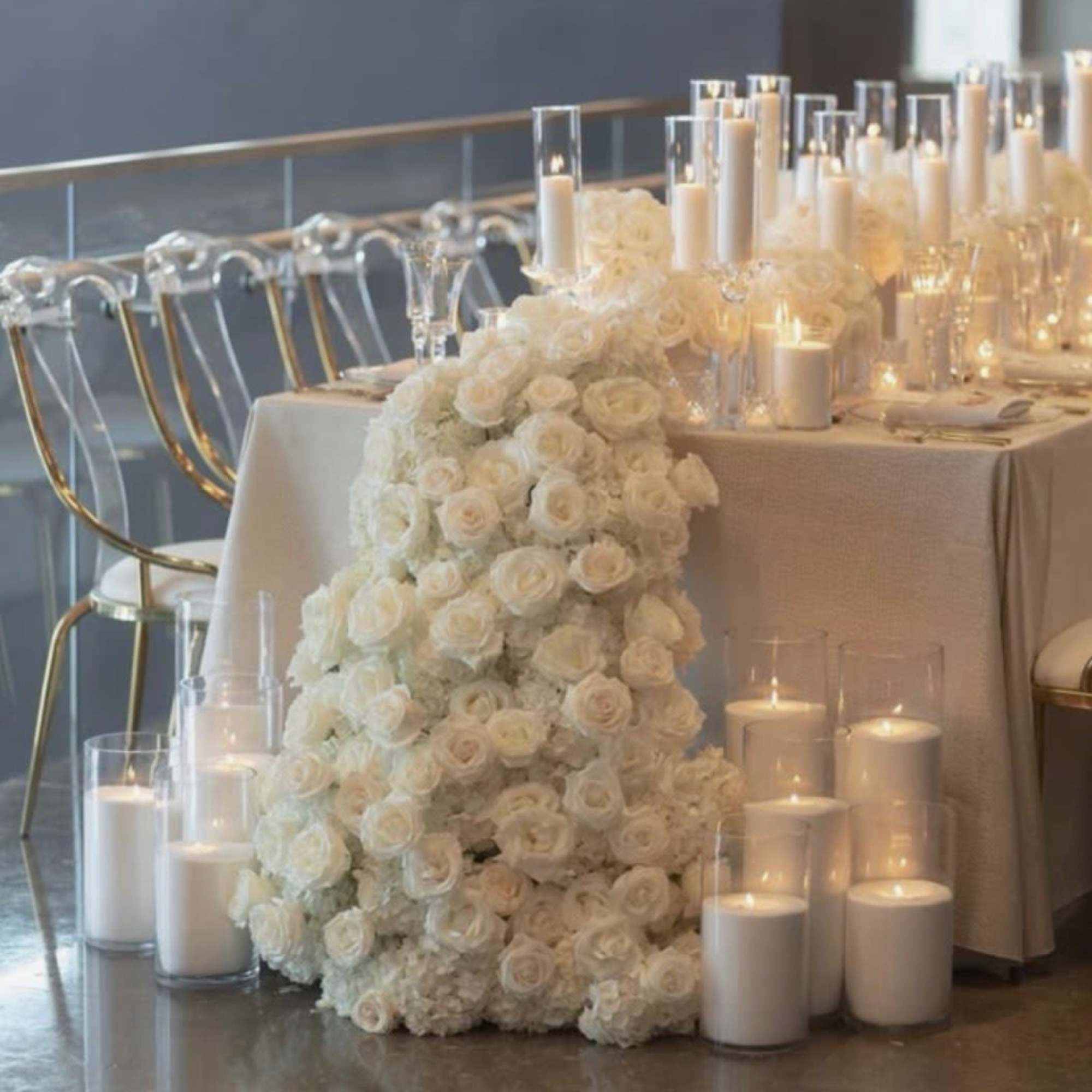 White rose floral arrangement with candles on a table