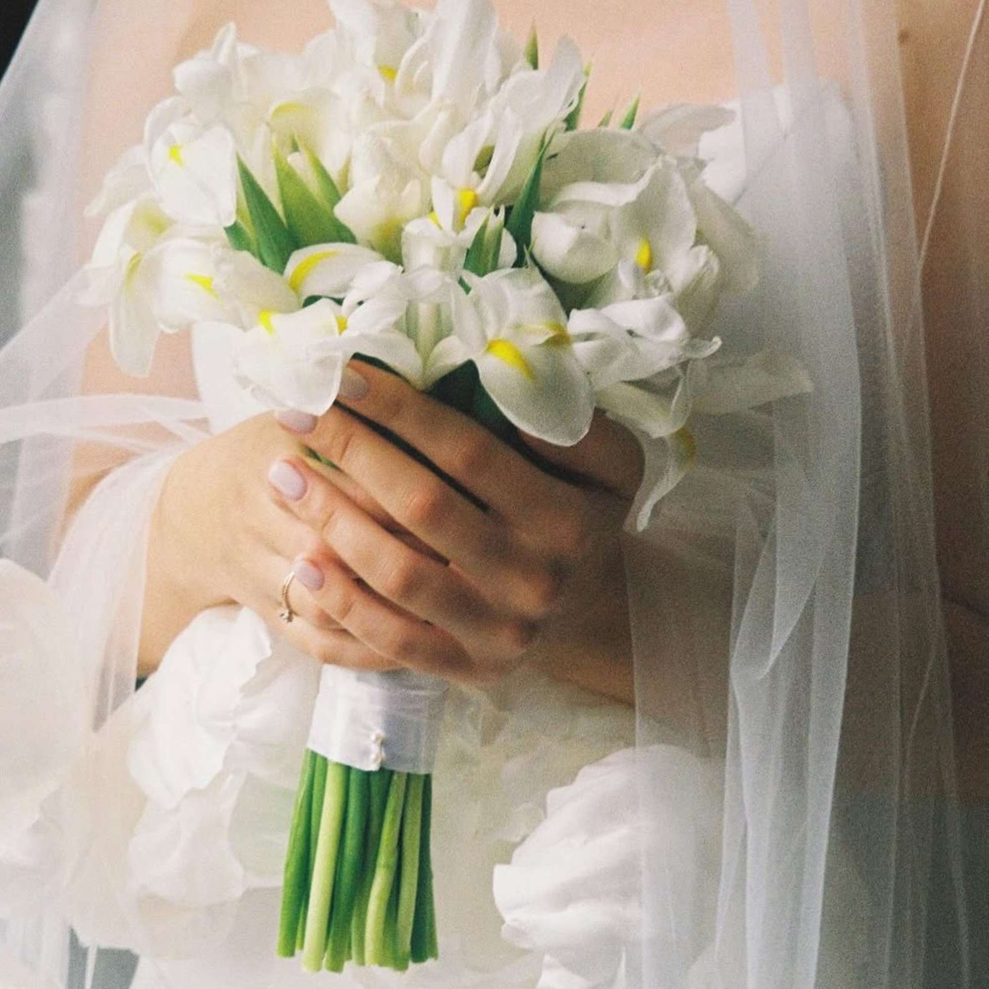 Bride holding a bouquet of white calla lilies