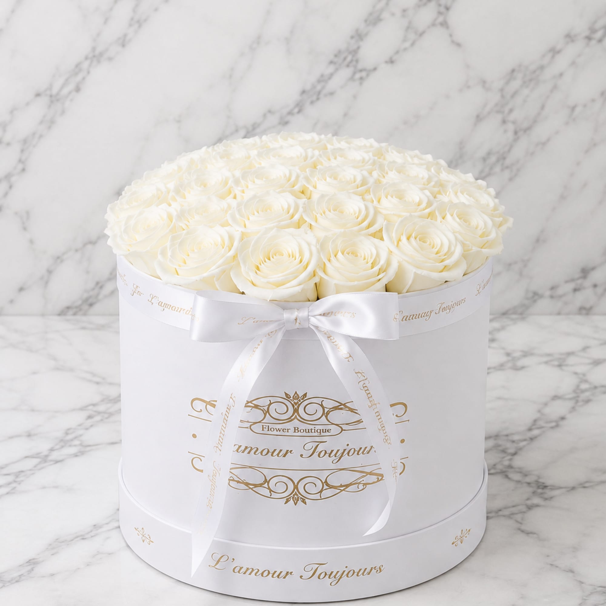 Round box of white roses tied with a white ribbon