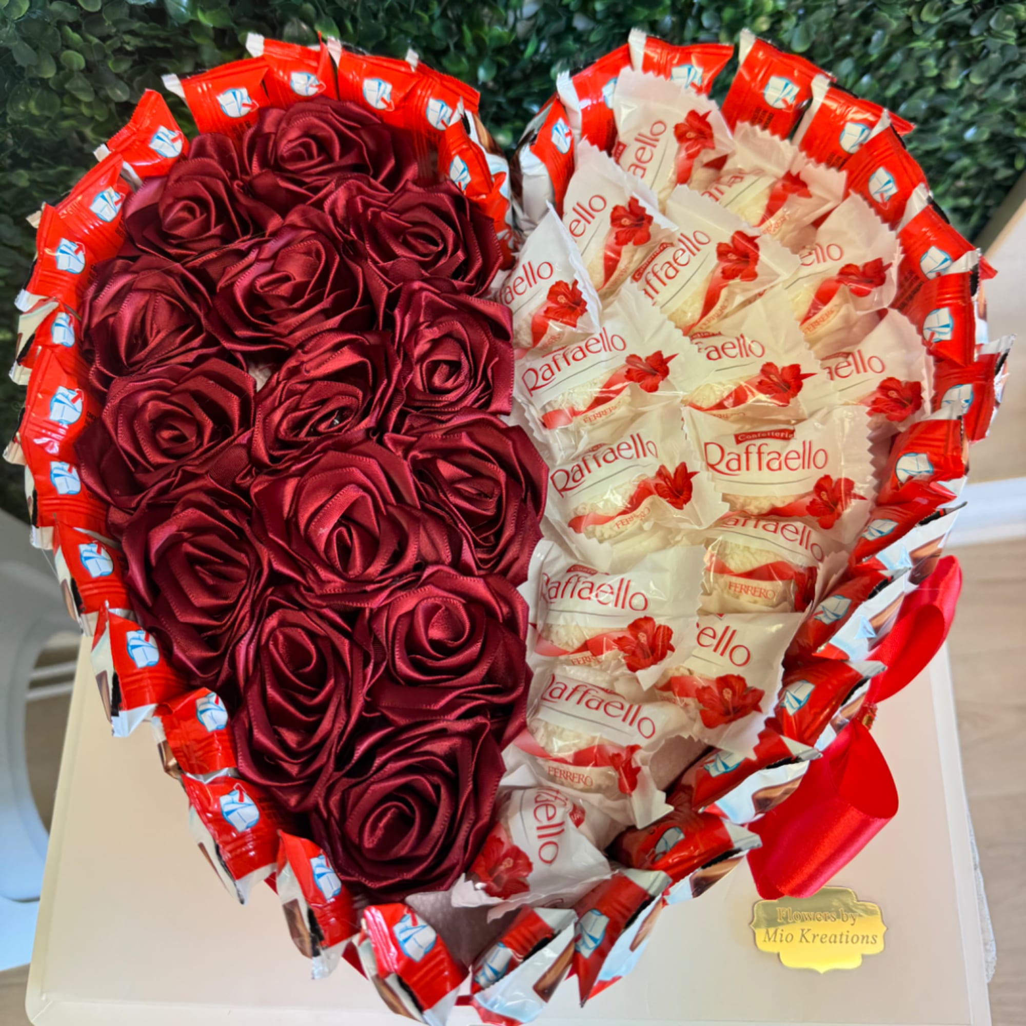 Heart-shaped gift arrangement with red satin roses and Raffaello candies