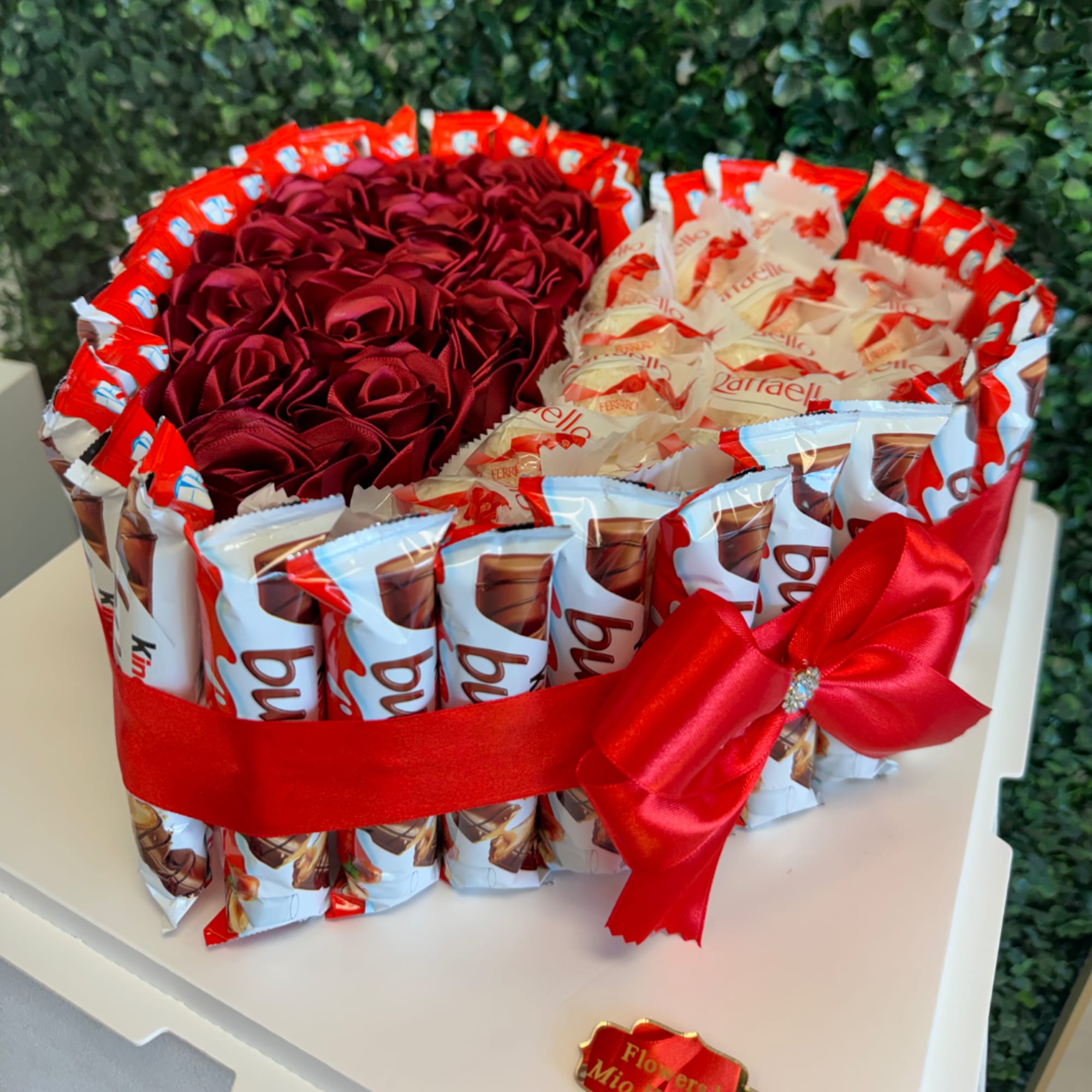 Heart-shaped chocolate gift box with red ribbon and rose decorations