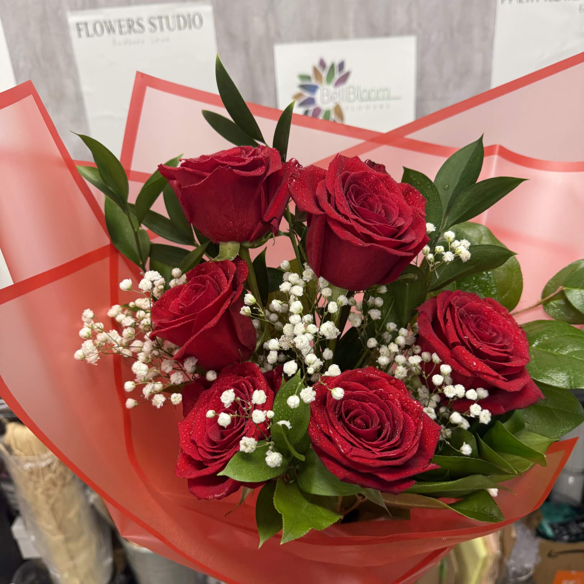 Bouquet of red roses with white baby's breath in red wrap