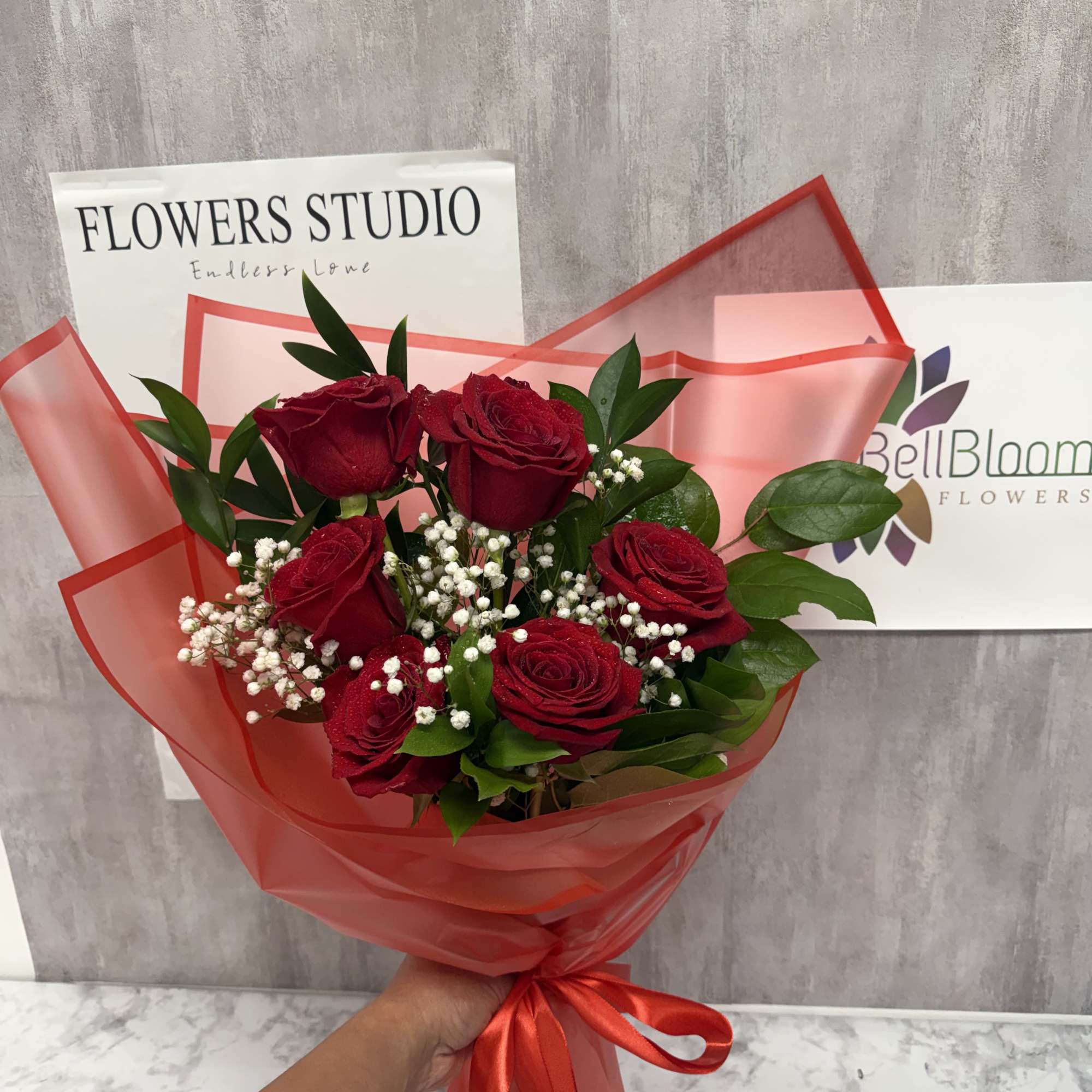 Bouquet of red roses with baby's breath wrapped in red paper