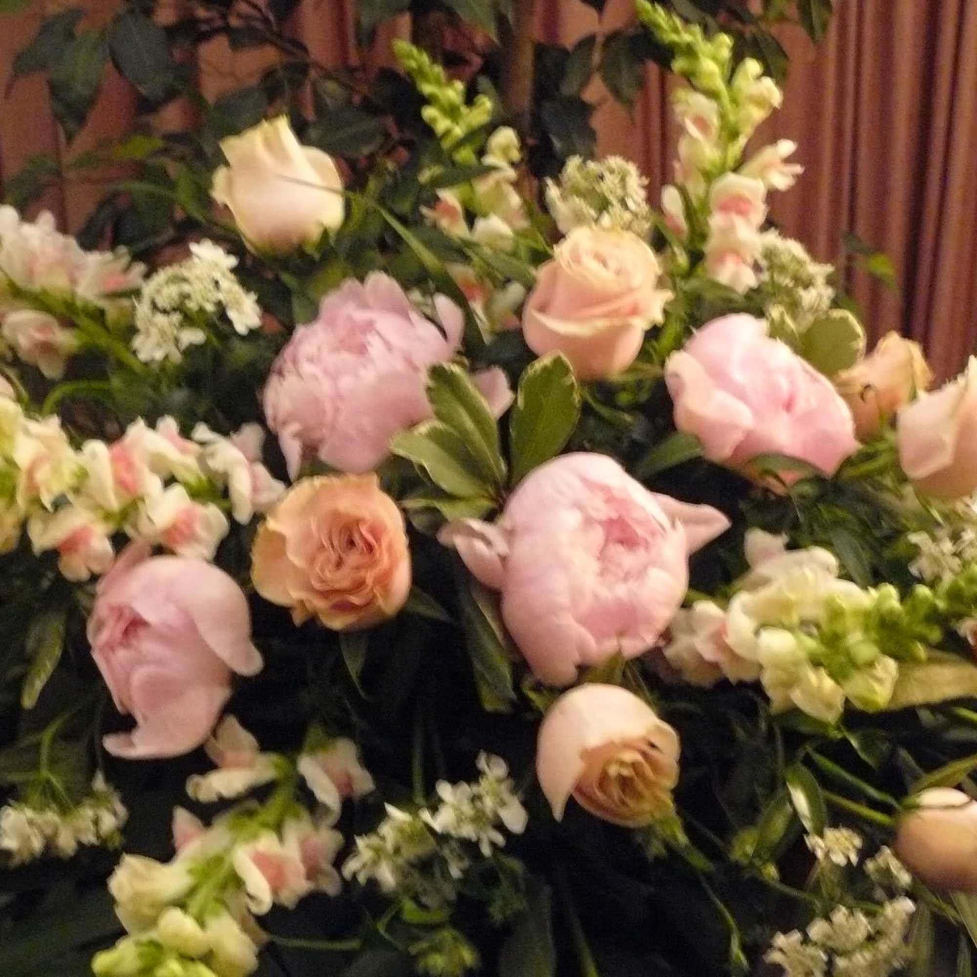 Large arrangement of pale pink roses and peonies with white filler flowers