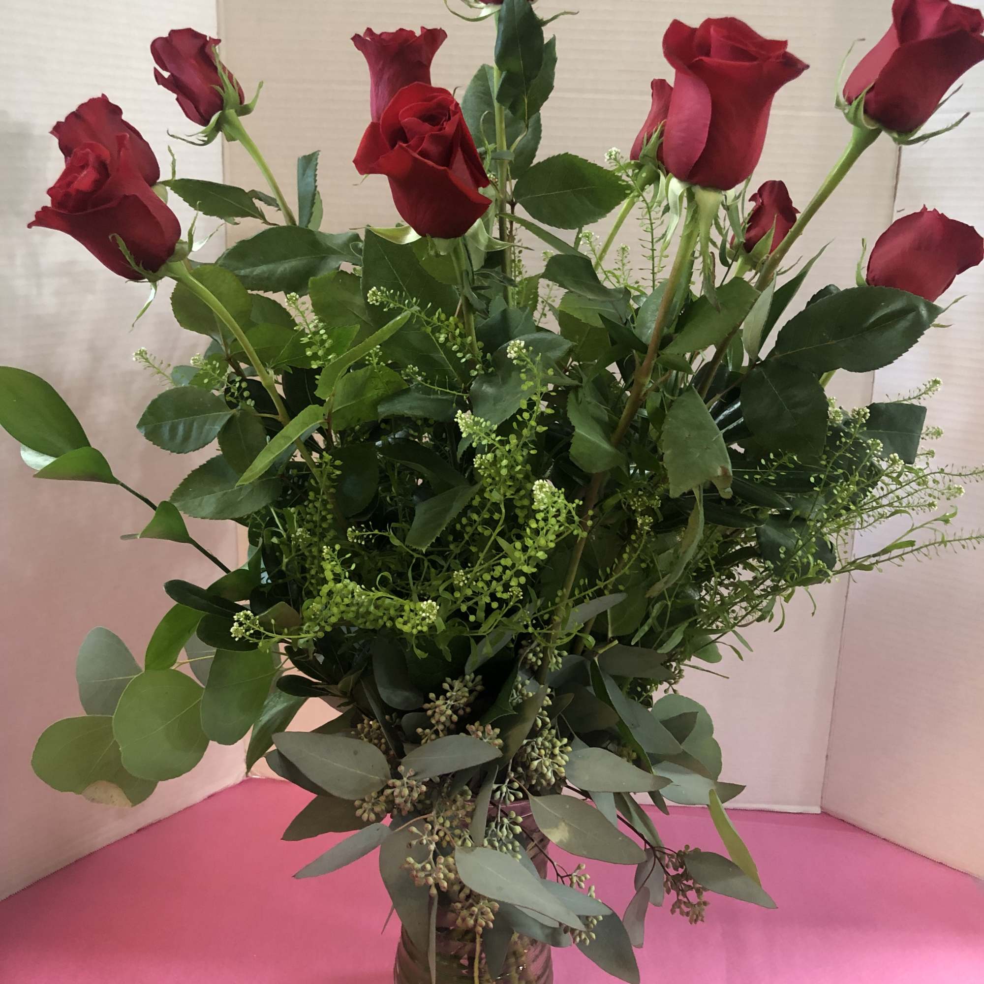 Tall bouquet of red roses in a glass vase