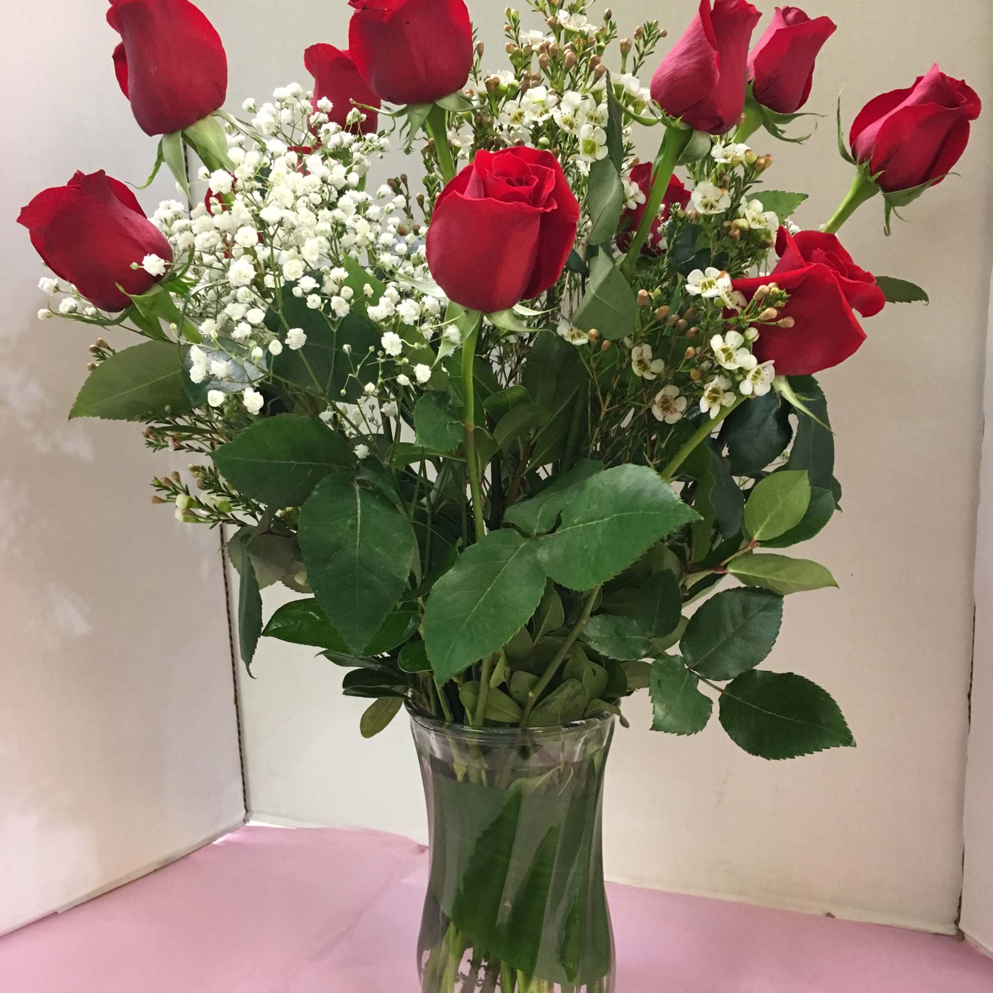 Red roses and white baby's breath in a clear glass vase