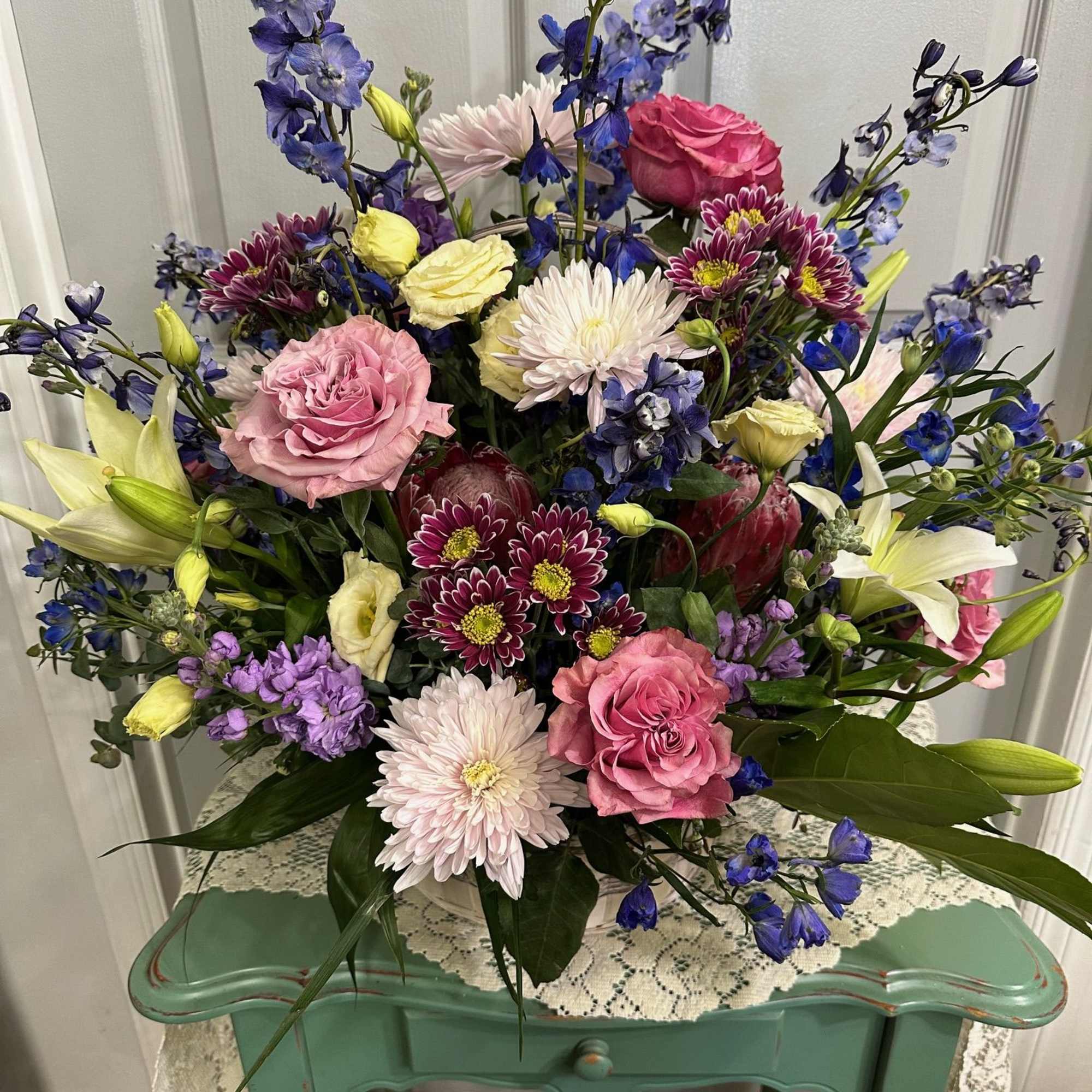 Mixed bouquet with pink roses, white lilies, and blue delphinium