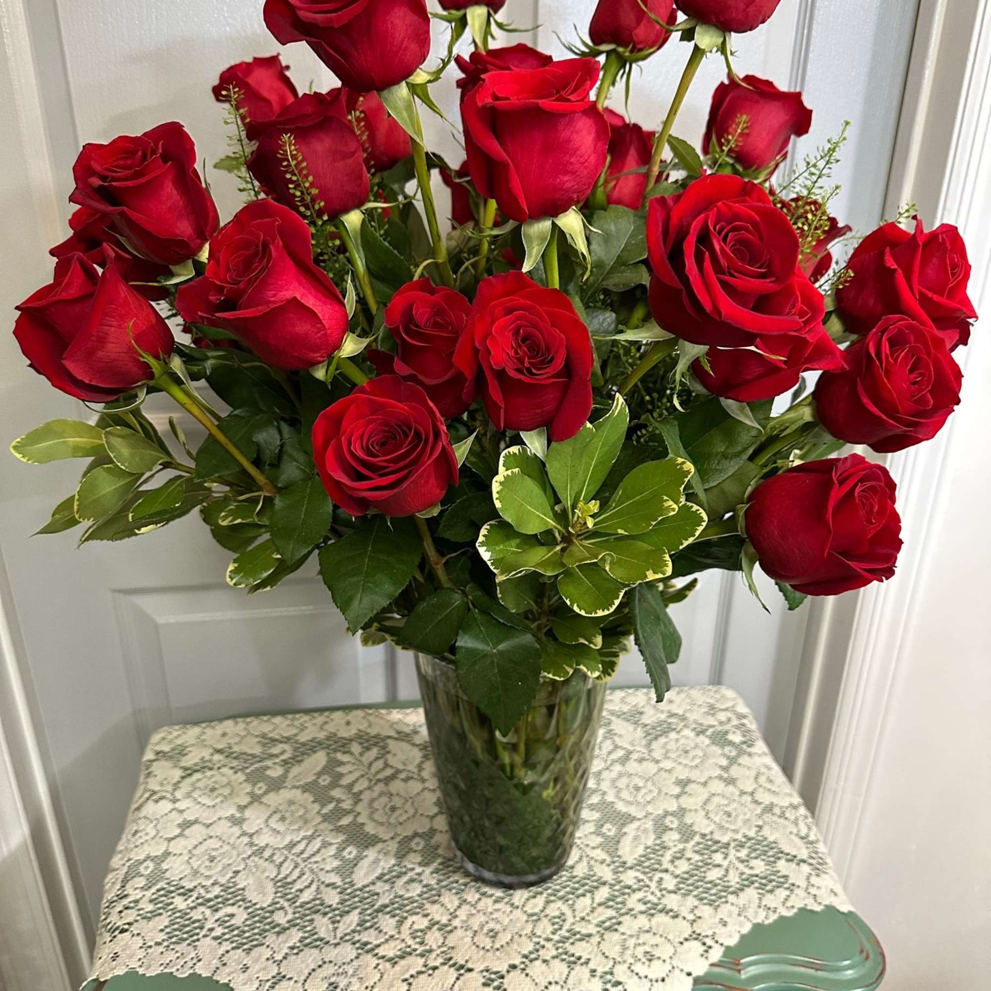 Red roses arranged in a clear glass vase