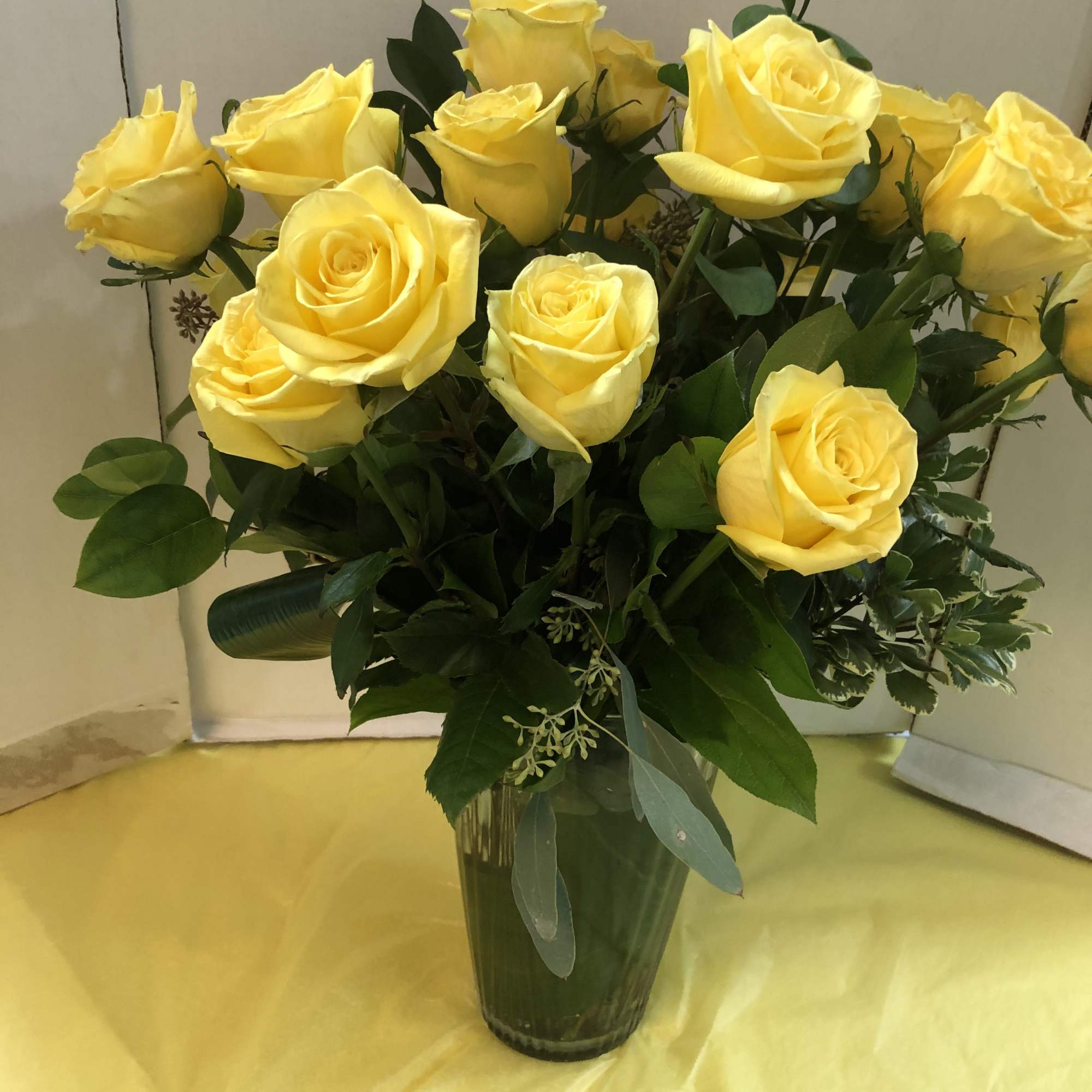 Yellow roses arranged in a clear glass vase