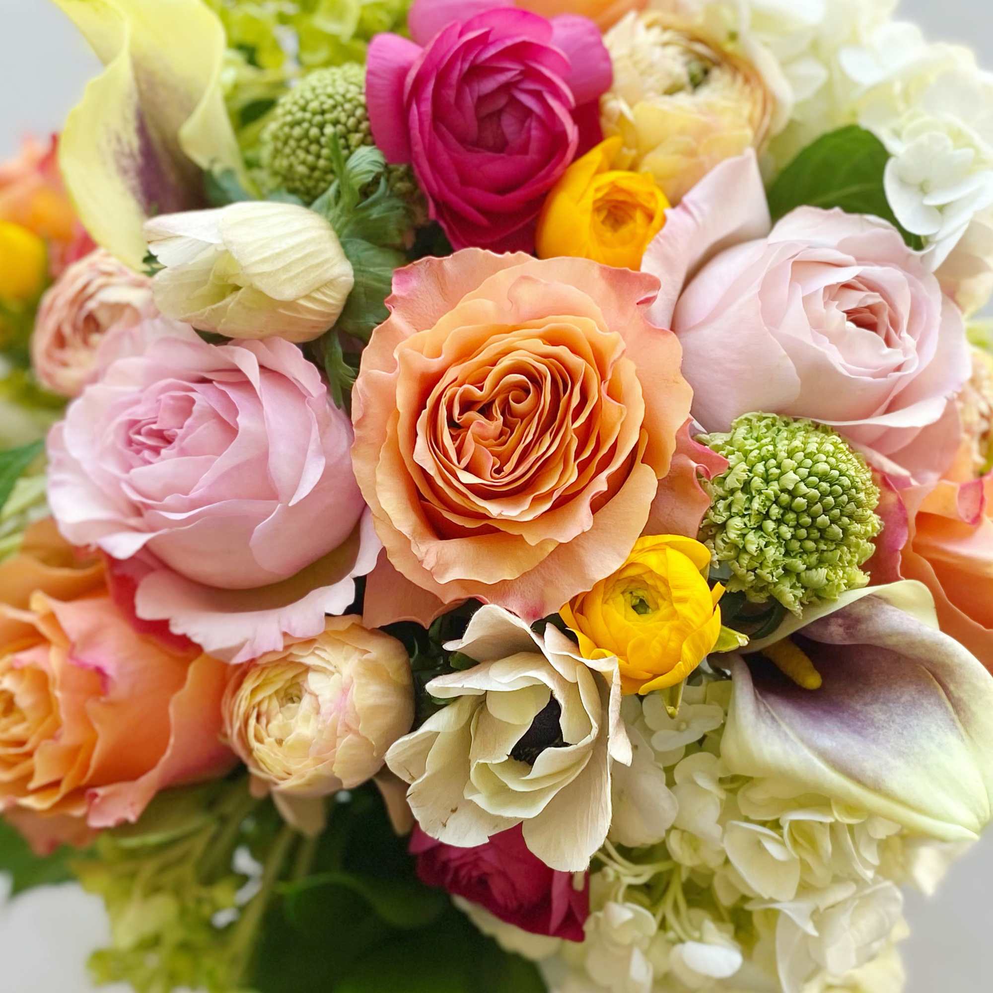 Bouquet of pastel roses, ranunculus, and calla lilies