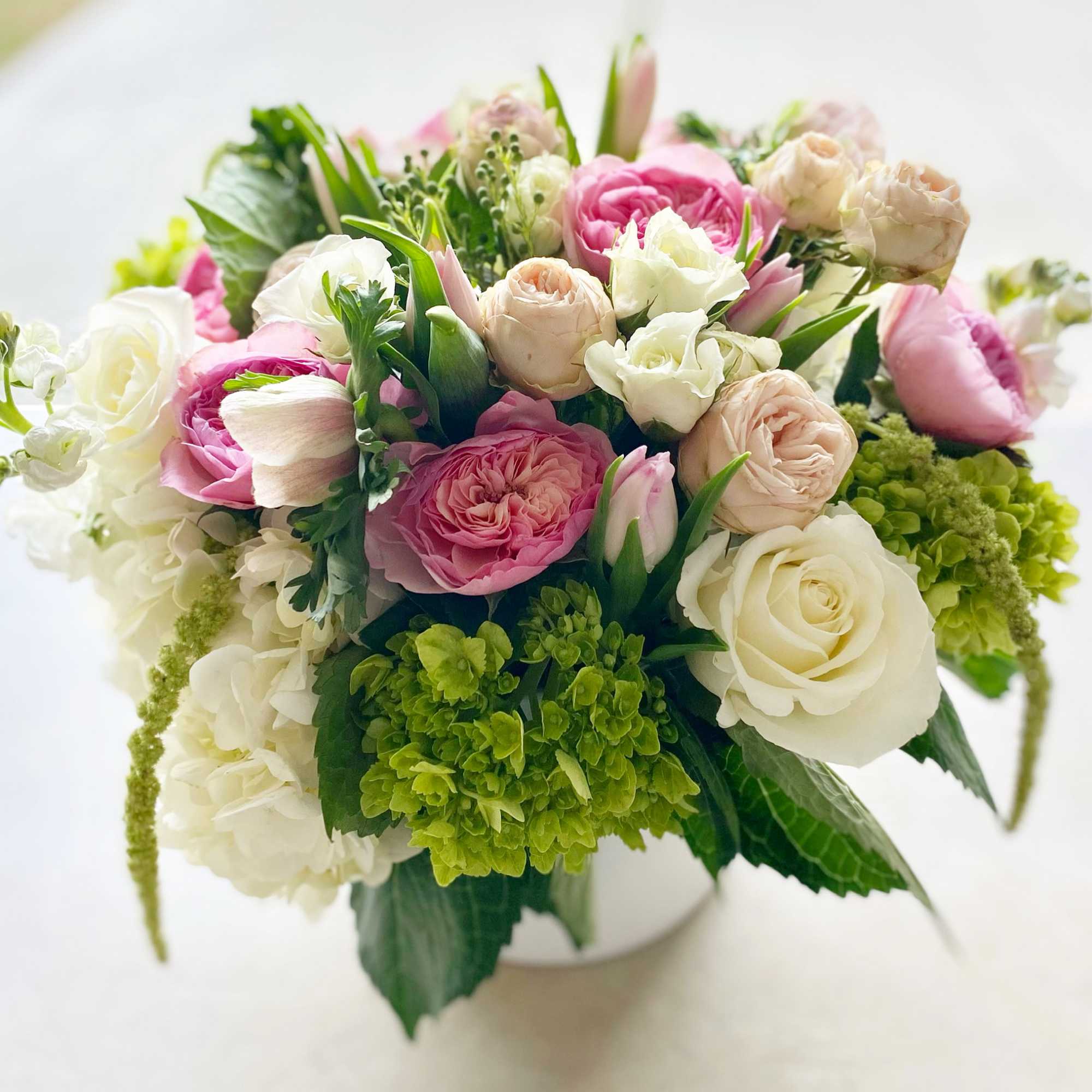 Pink and white rose bouquet in a white vase