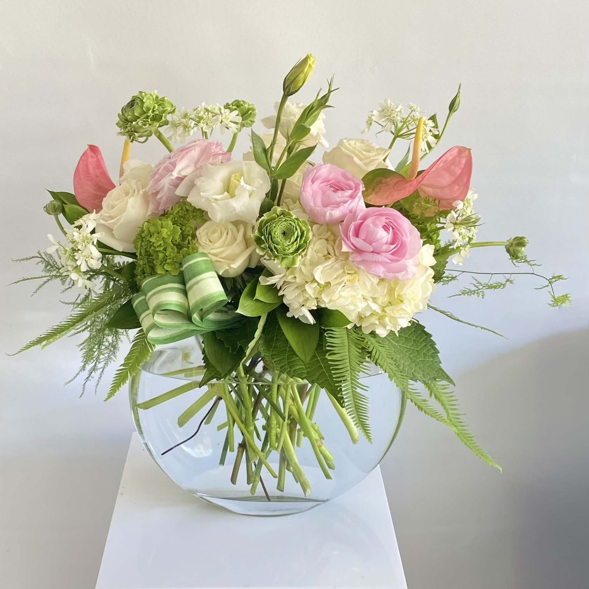 Pink and white mixed bouquet in a round glass vase