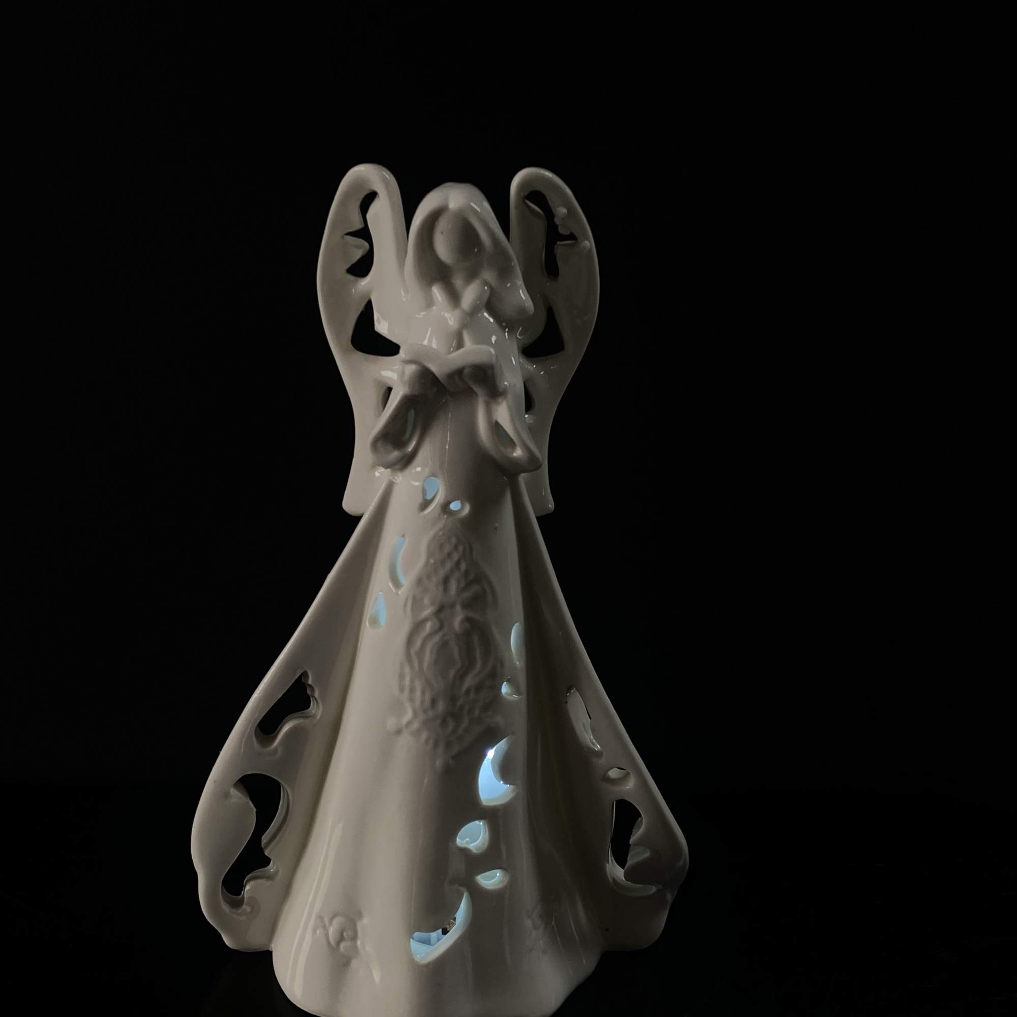White ceramic angel figurine with cutout details
