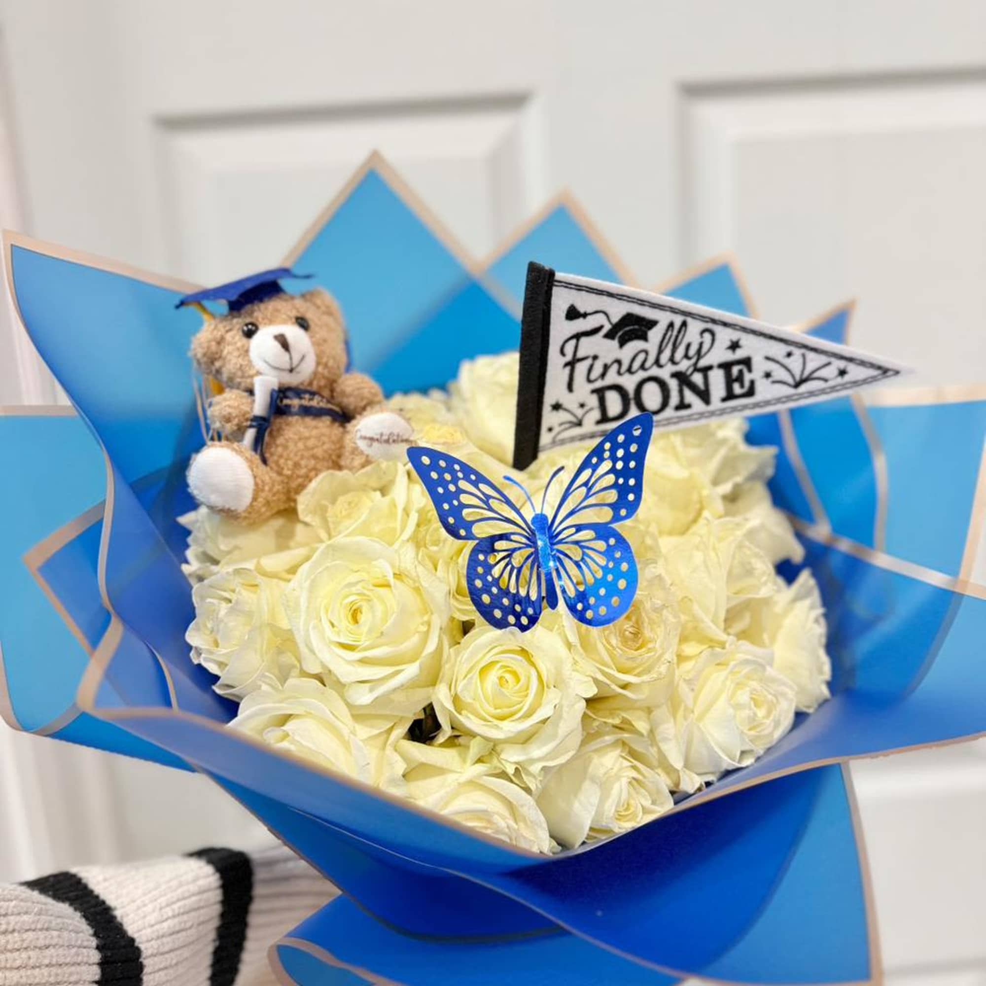Bouquet of cream roses with a teddy bear and graduation flag