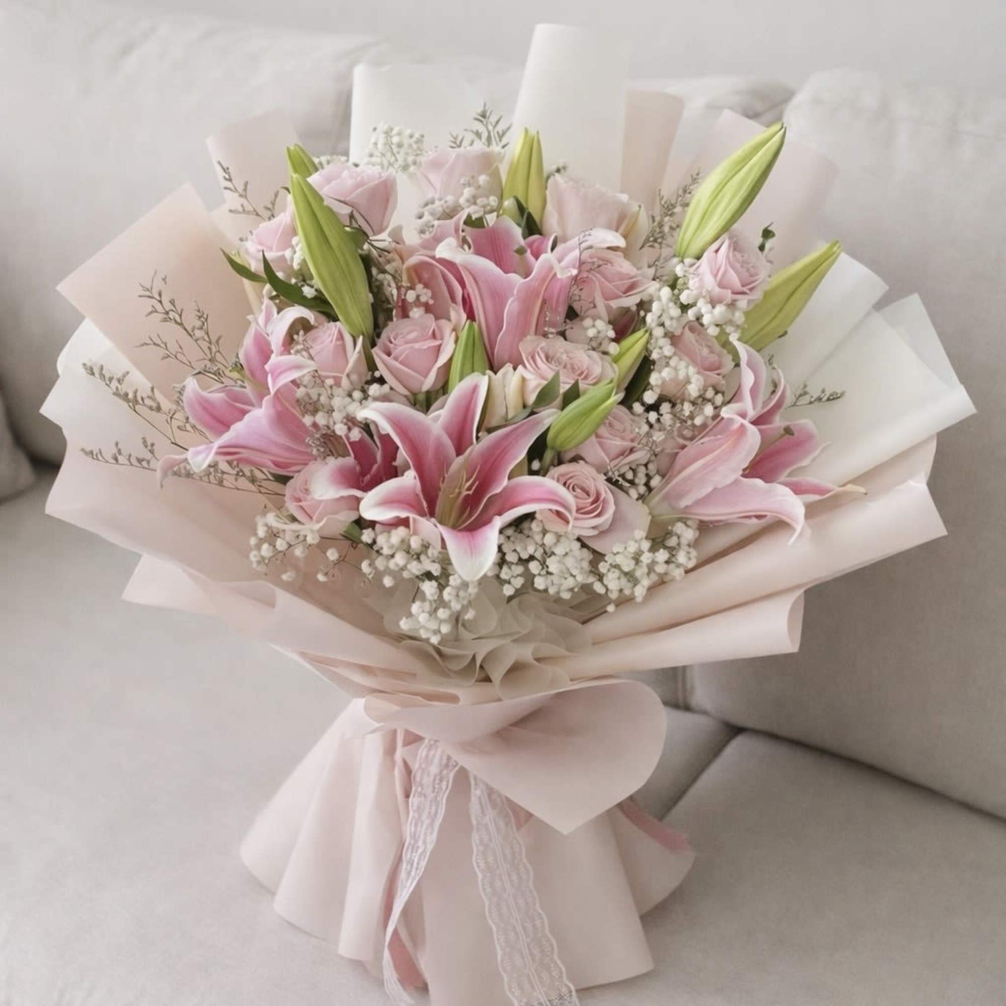 Pink lilies and roses bouquet wrapped in pale paper