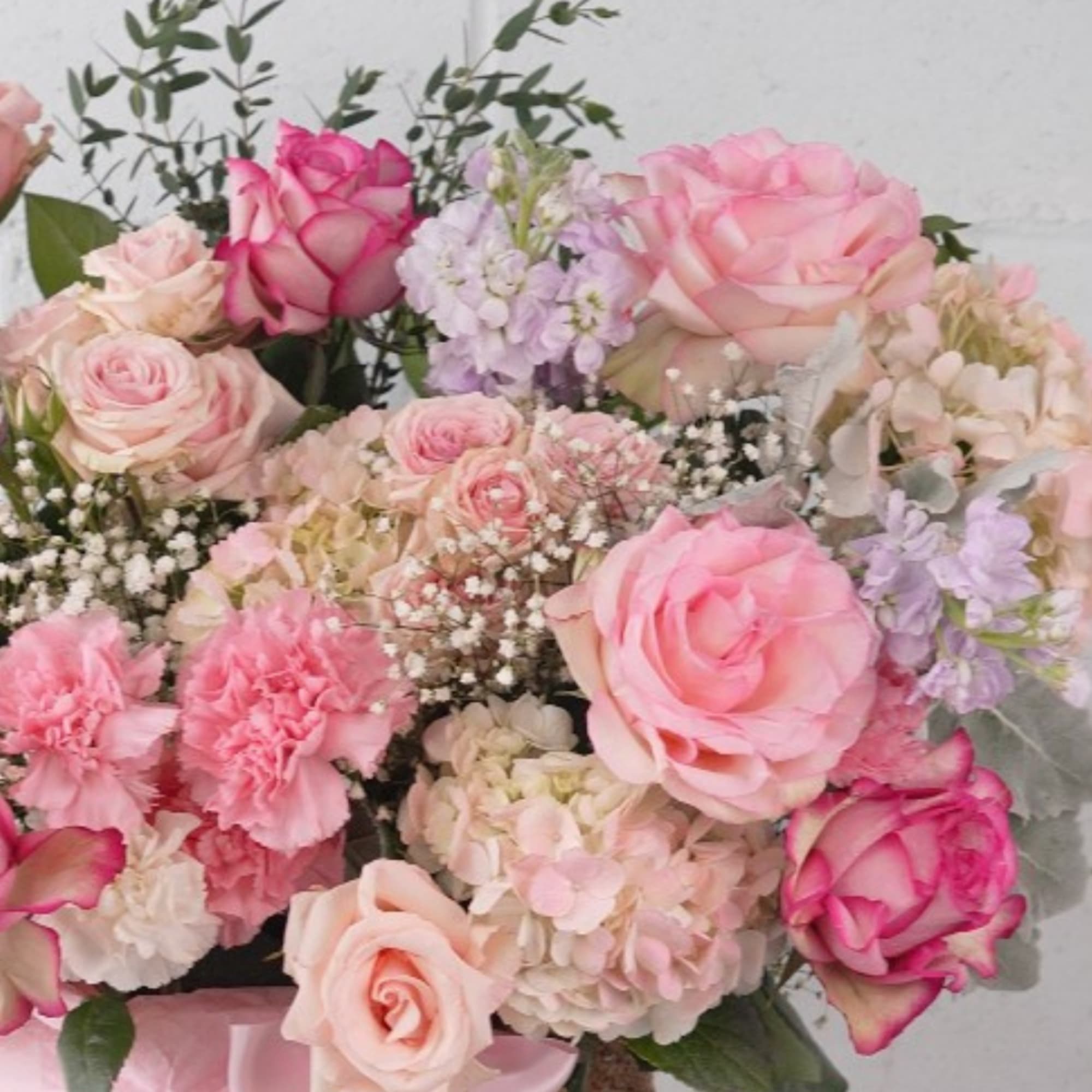 Pink and blush roses with hydrangeas in a woven basket