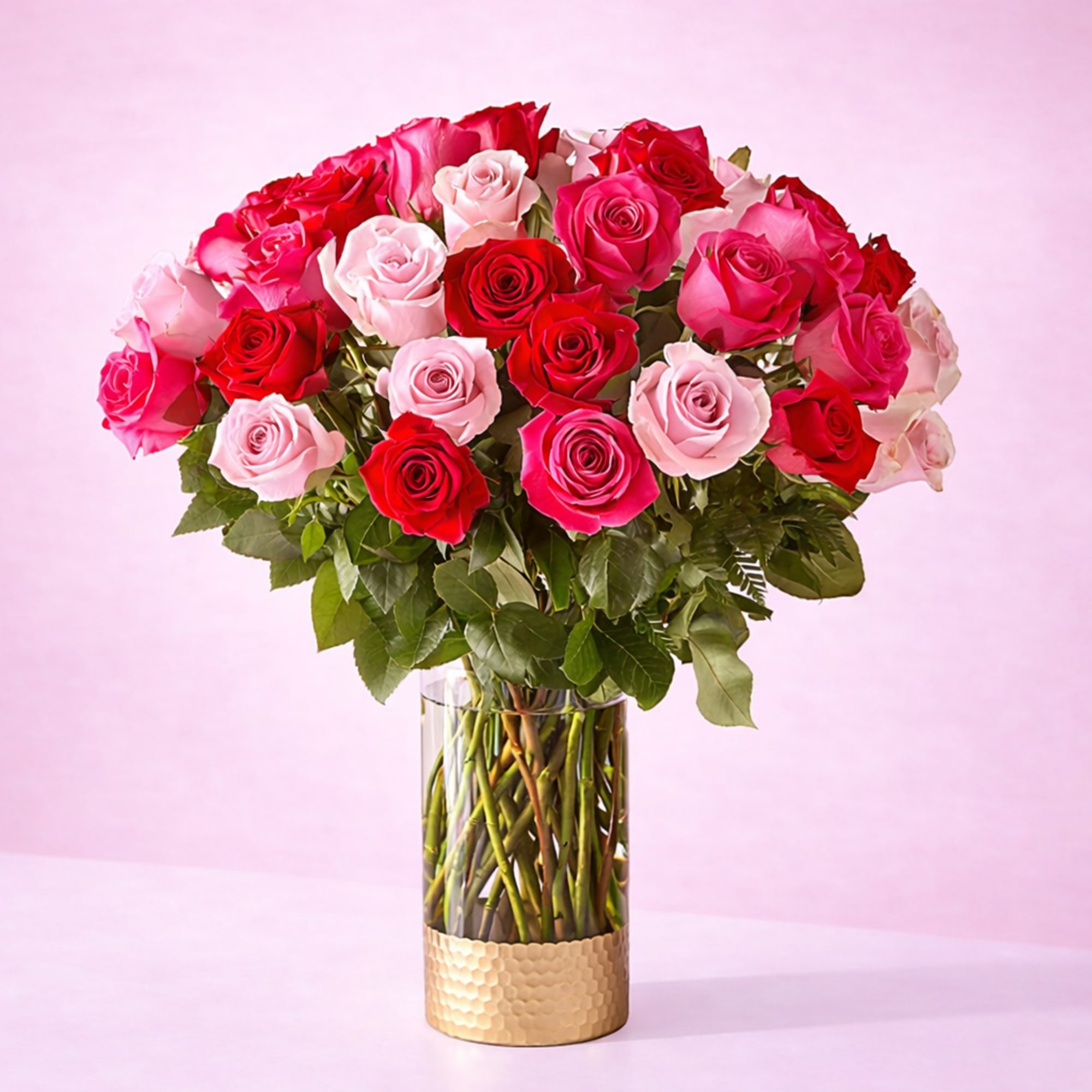 English:
Premium long-stem rose arrangement in fuchsia, pink, and red tones, presented in