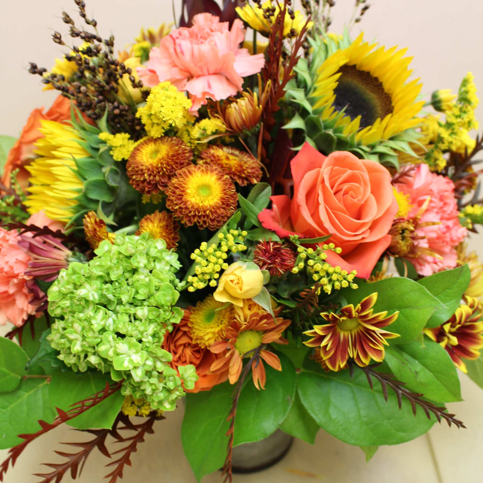 Mixed bouquet with sunflowers, roses, and chrysanthemums in a vase