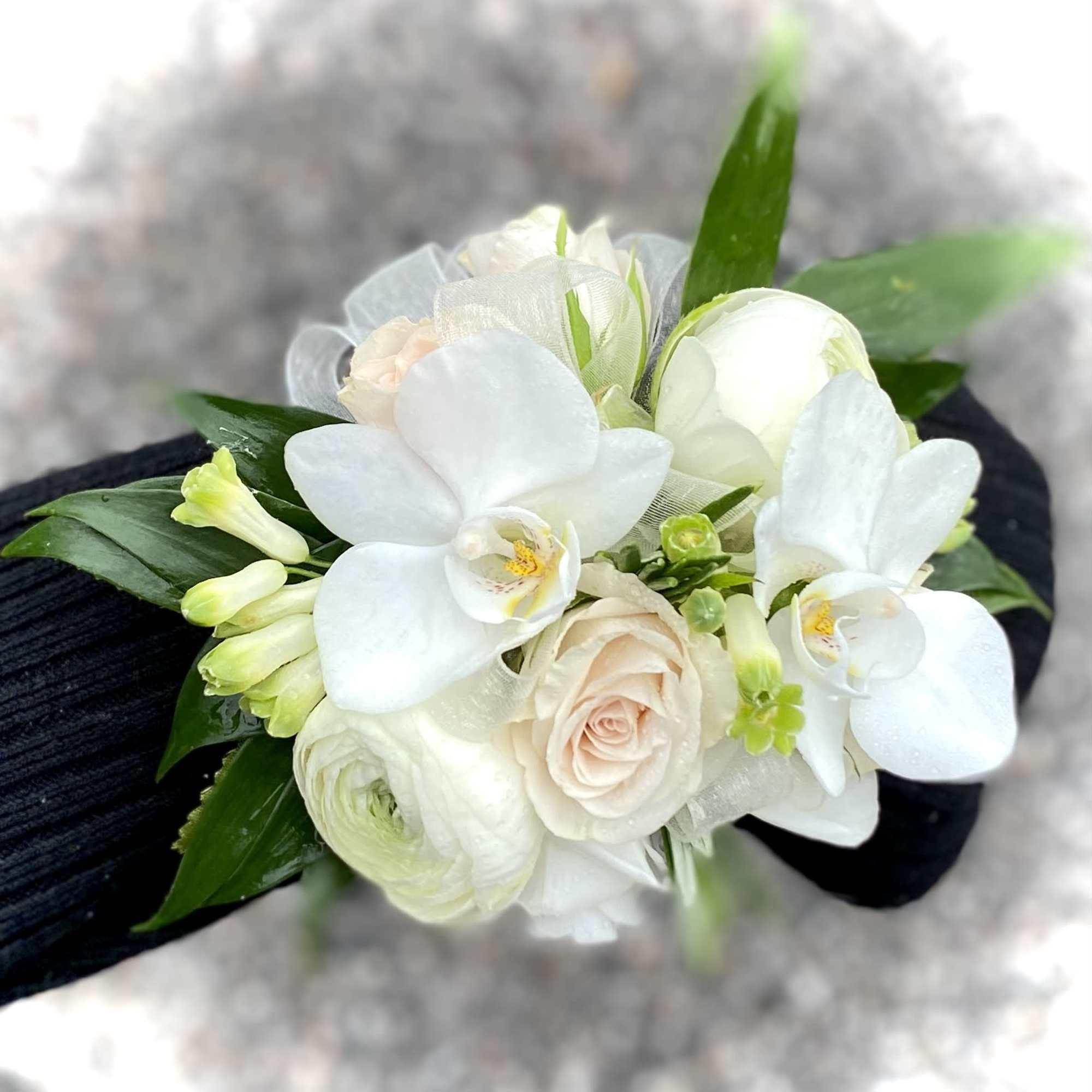 White orchid and rose wrist corsage with green accents