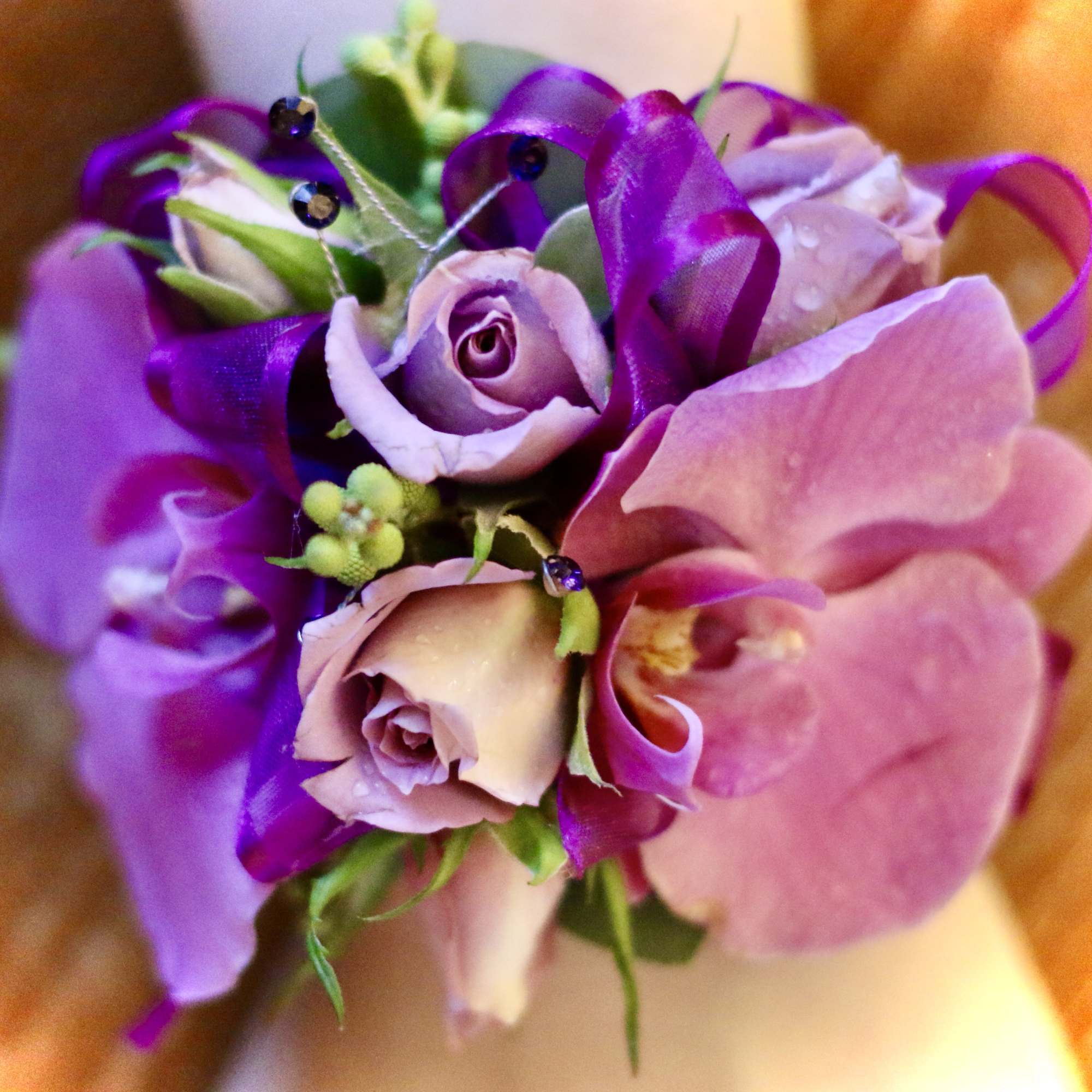 Small bouquet of pink and purple flowers with ribbon accents