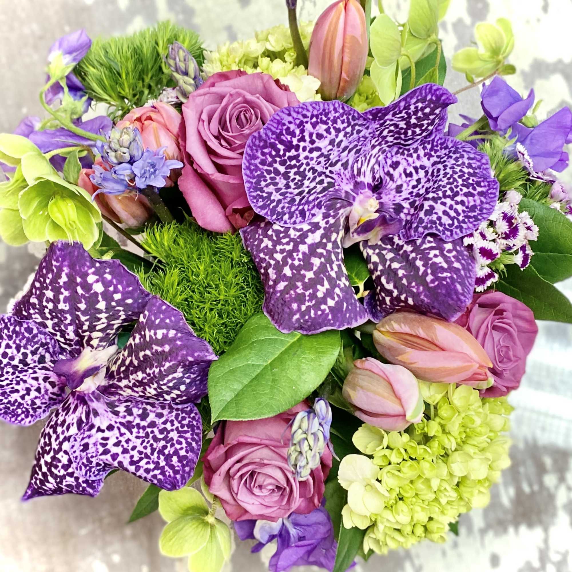 Bouquet of purple orchids, pink roses, and green hydrangeas