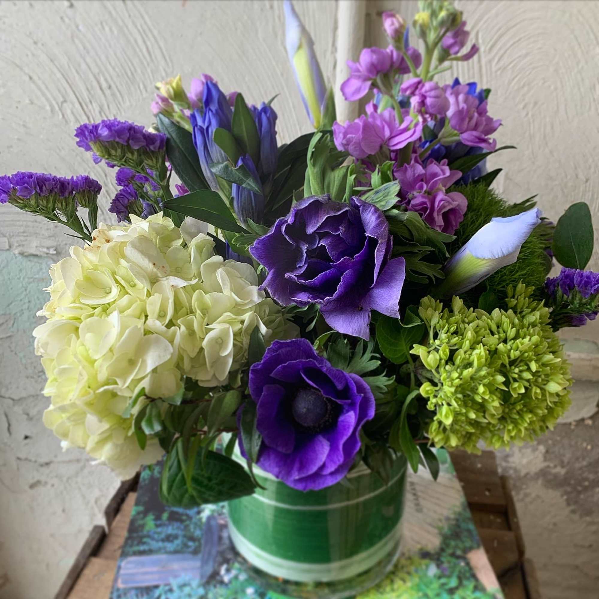 Purple and white floral arrangement in a glass vase