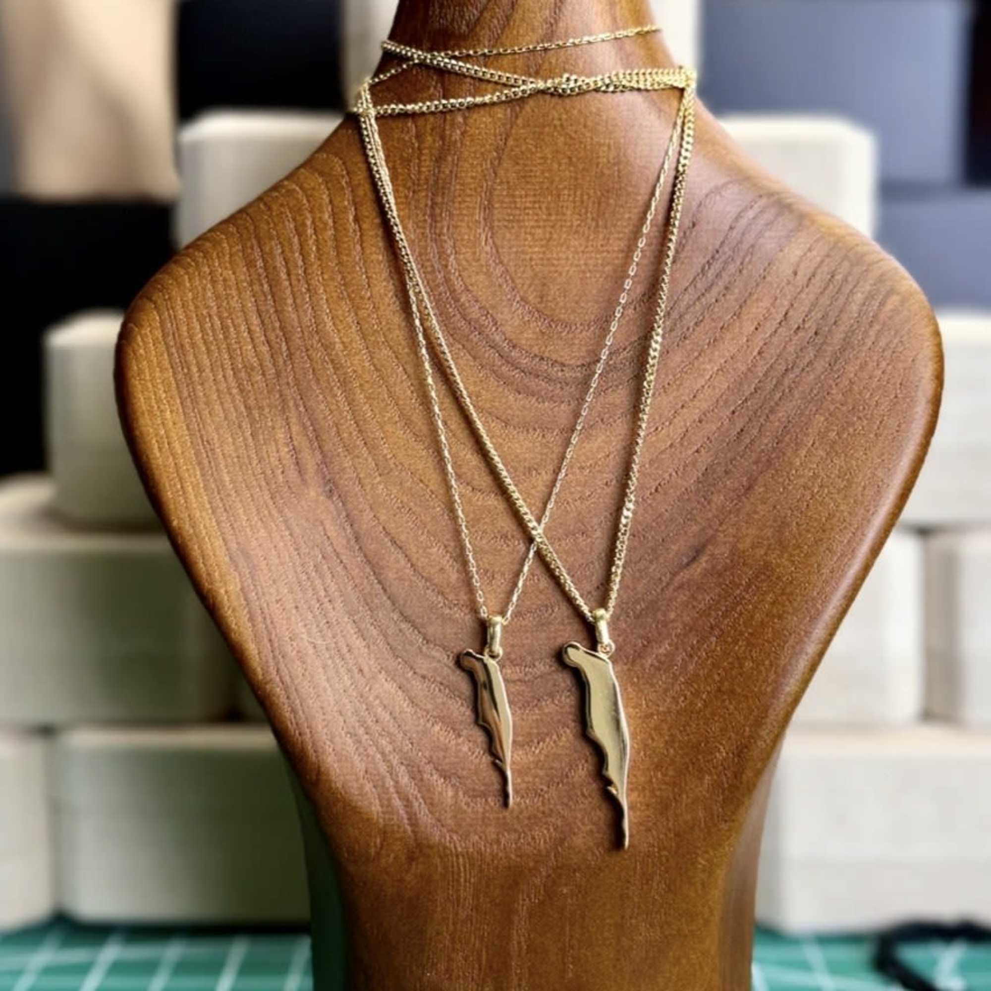 Gold necklaces displayed on a wooden bust stand