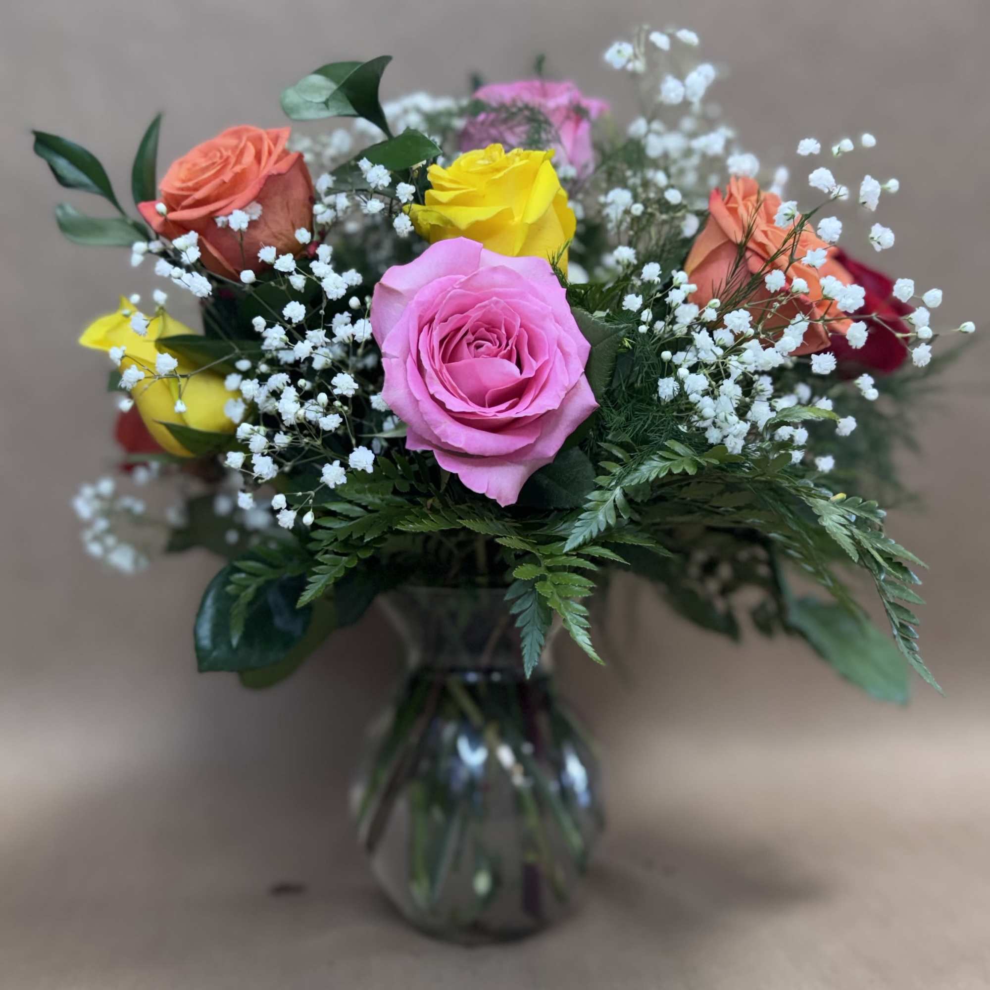 Mixed roses in a glass vase with baby's breath