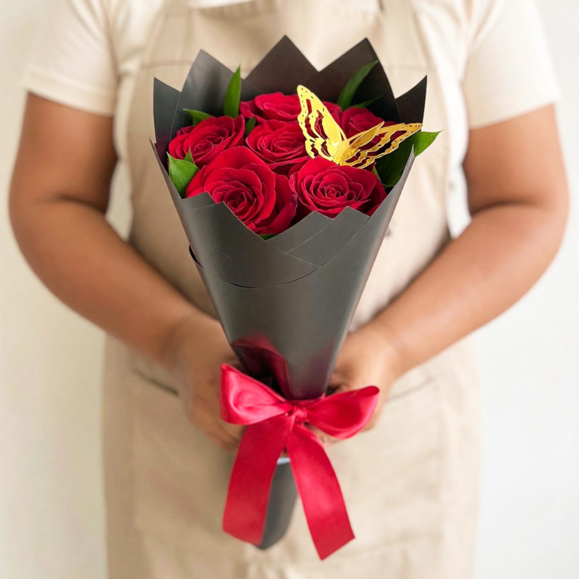 Bouquet of red roses wrapped in black paper with a red ribbon