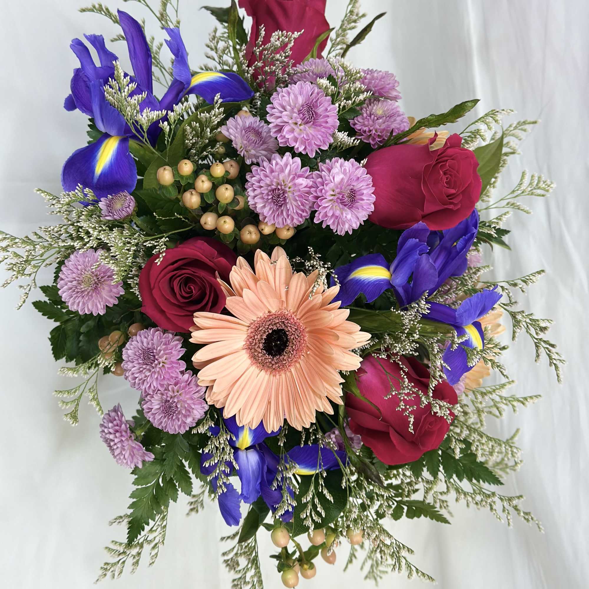 Bouquet of pink roses, purple irises, and a peach gerbera daisy