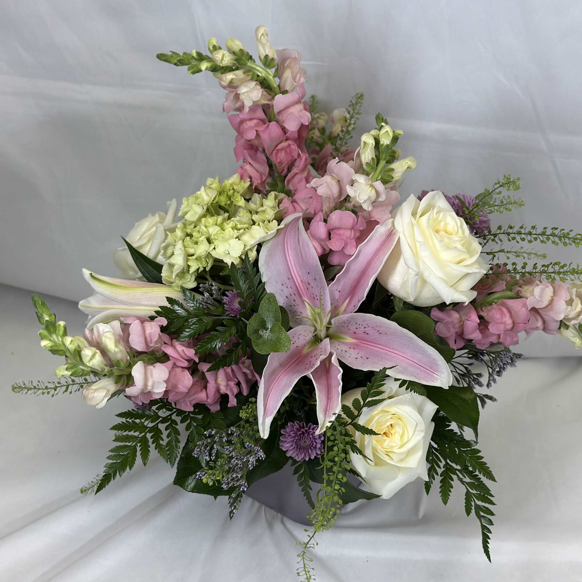 Pink and white floral arrangement with roses and lilies