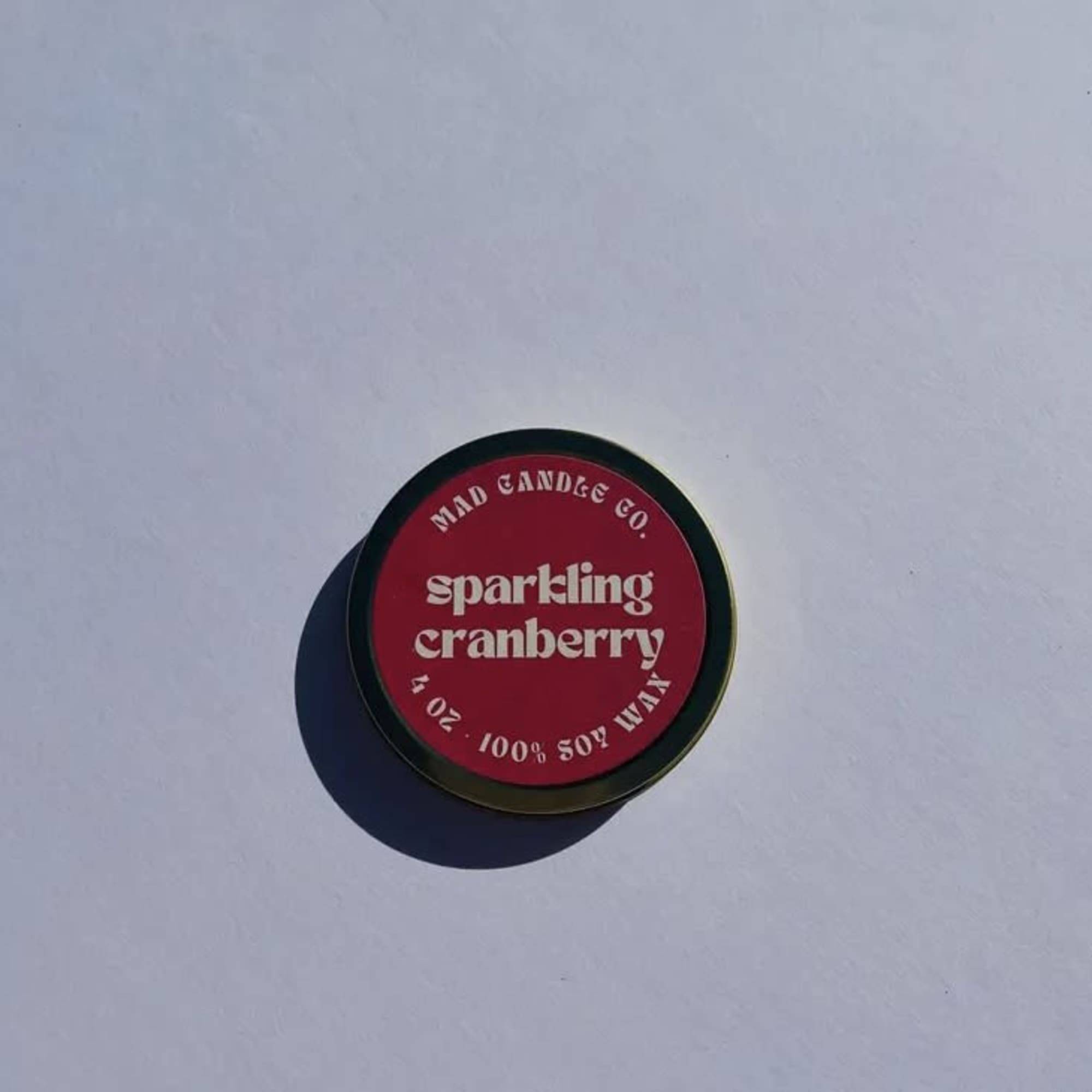 Round tin candle labeled sparkling cranberry
