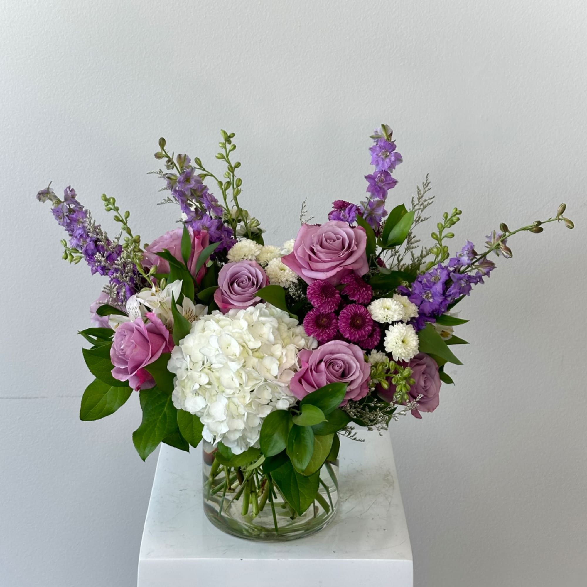Lavender and white flower arrangement in a clear glass vase