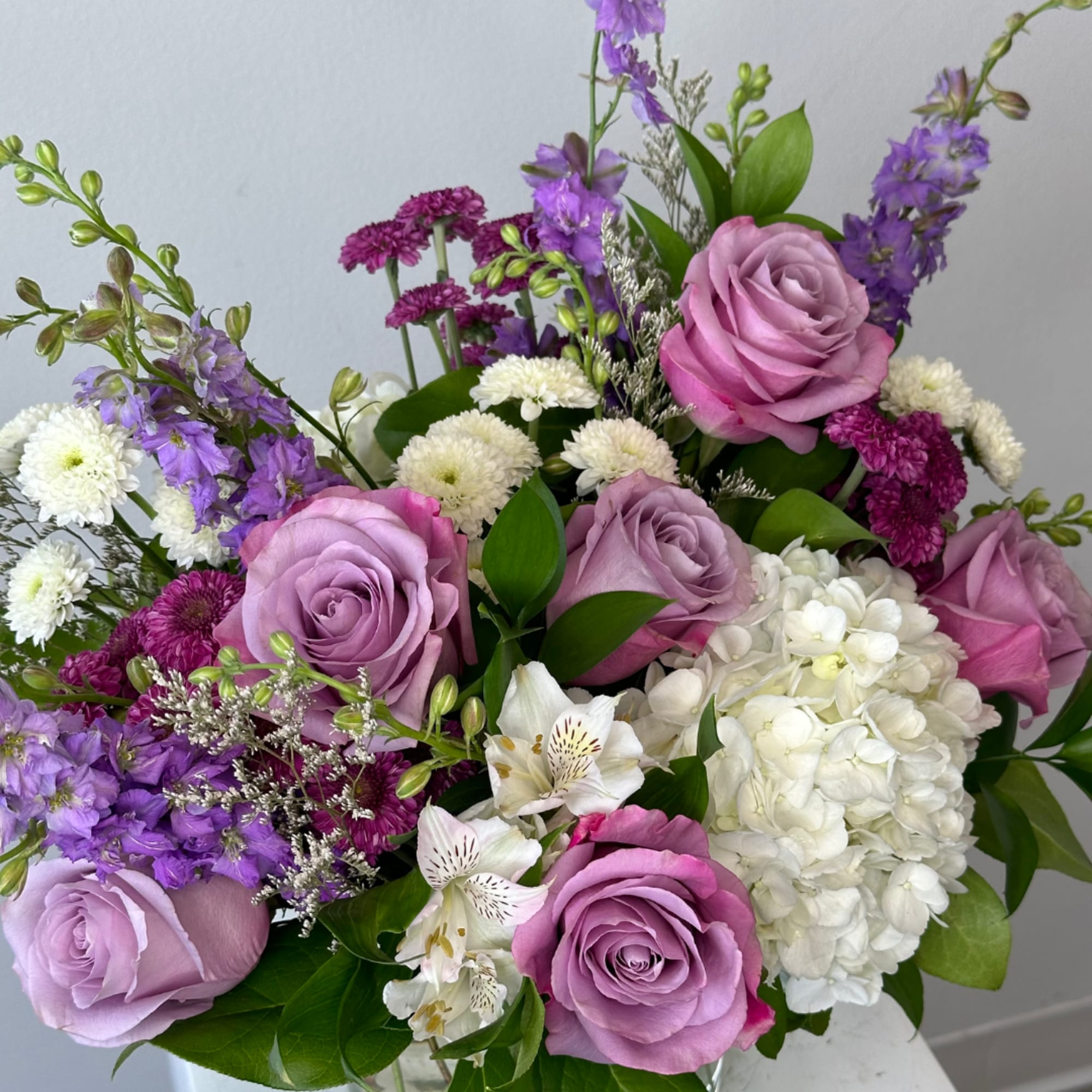 Bouquet of lavender roses, white hydrangea, and purple flowers