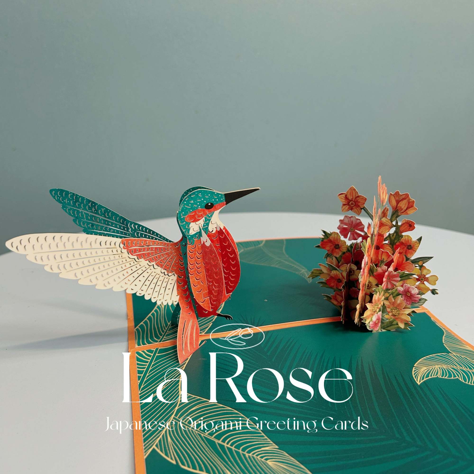 Pop-up greeting card with a colorful hummingbird and small paper flowers