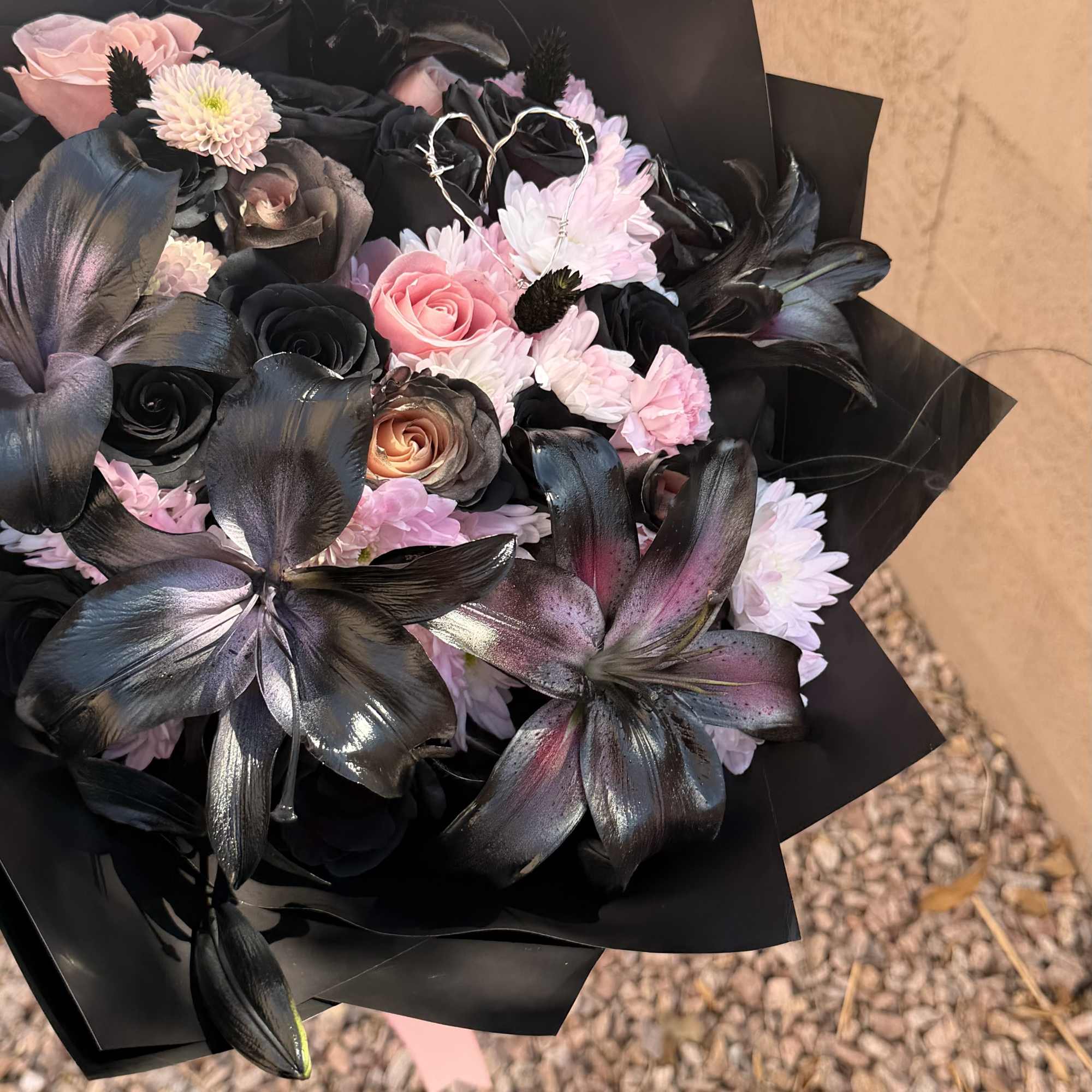 Bouquet of pink and black flowers wrapped in black paper