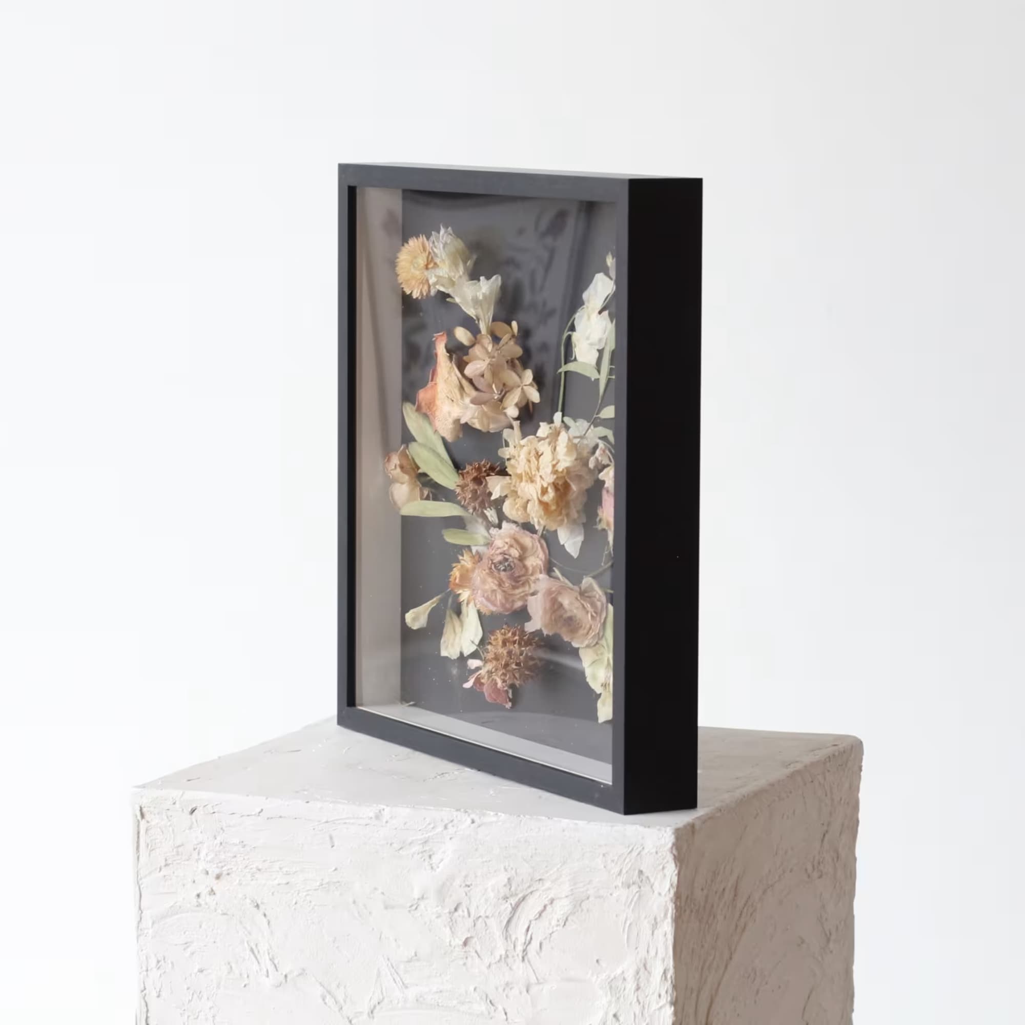 Framed dried flower arrangement in a black shadow box