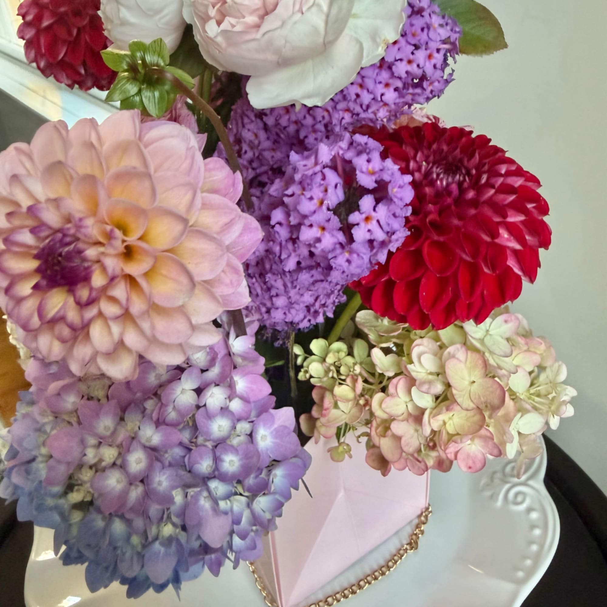 Bouquet of pastel and red dahlias with hydrangea in a pink box
