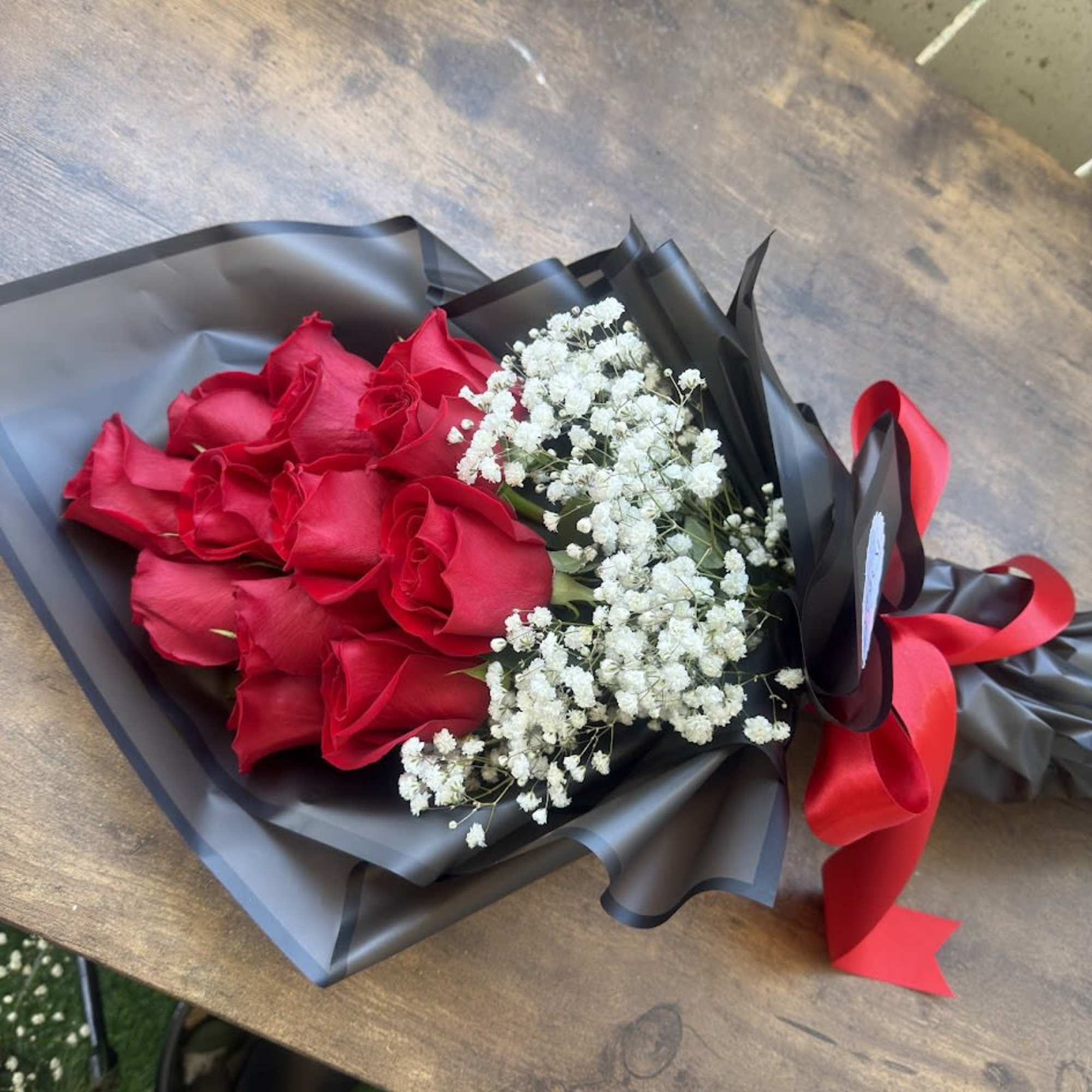 An elegant arrangement of fresh red roses, accompanied by delicate gypsophila that, photo 3 of 4