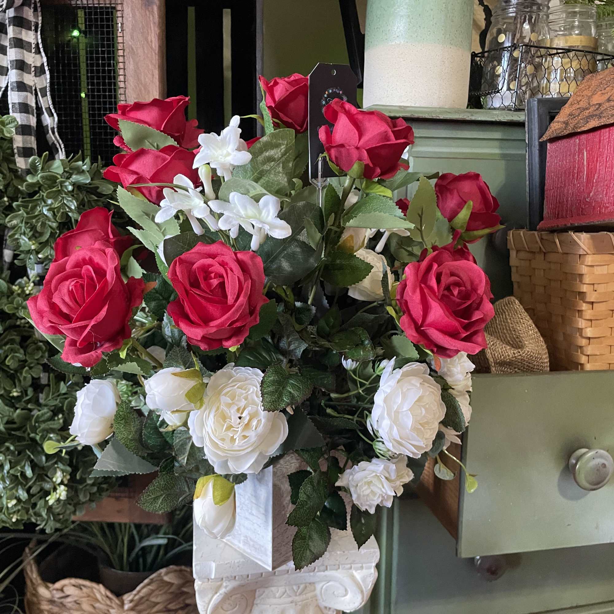 Arrangement of red and white roses in a white pedestal vase