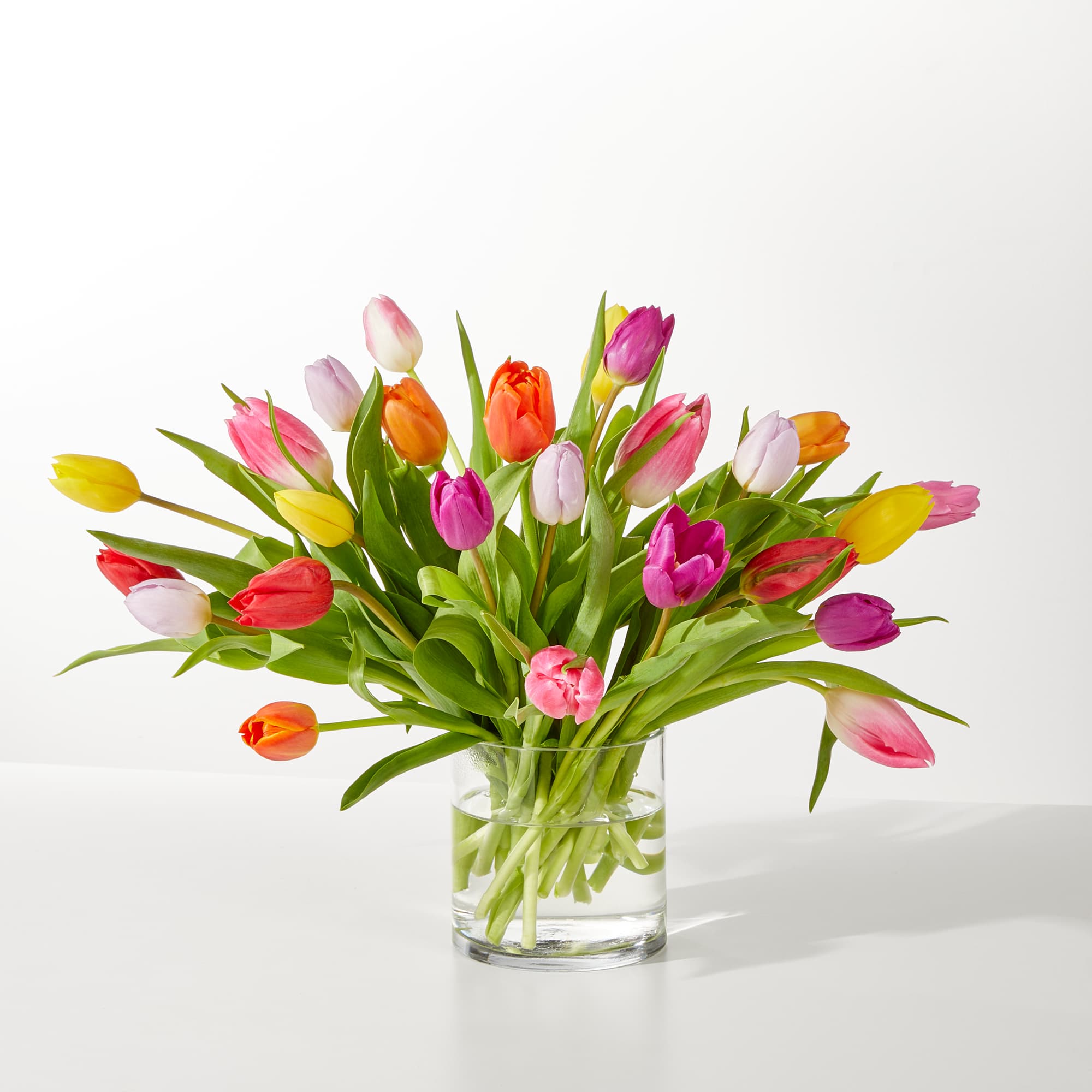 Colorful tulips arranged in a clear glass vase