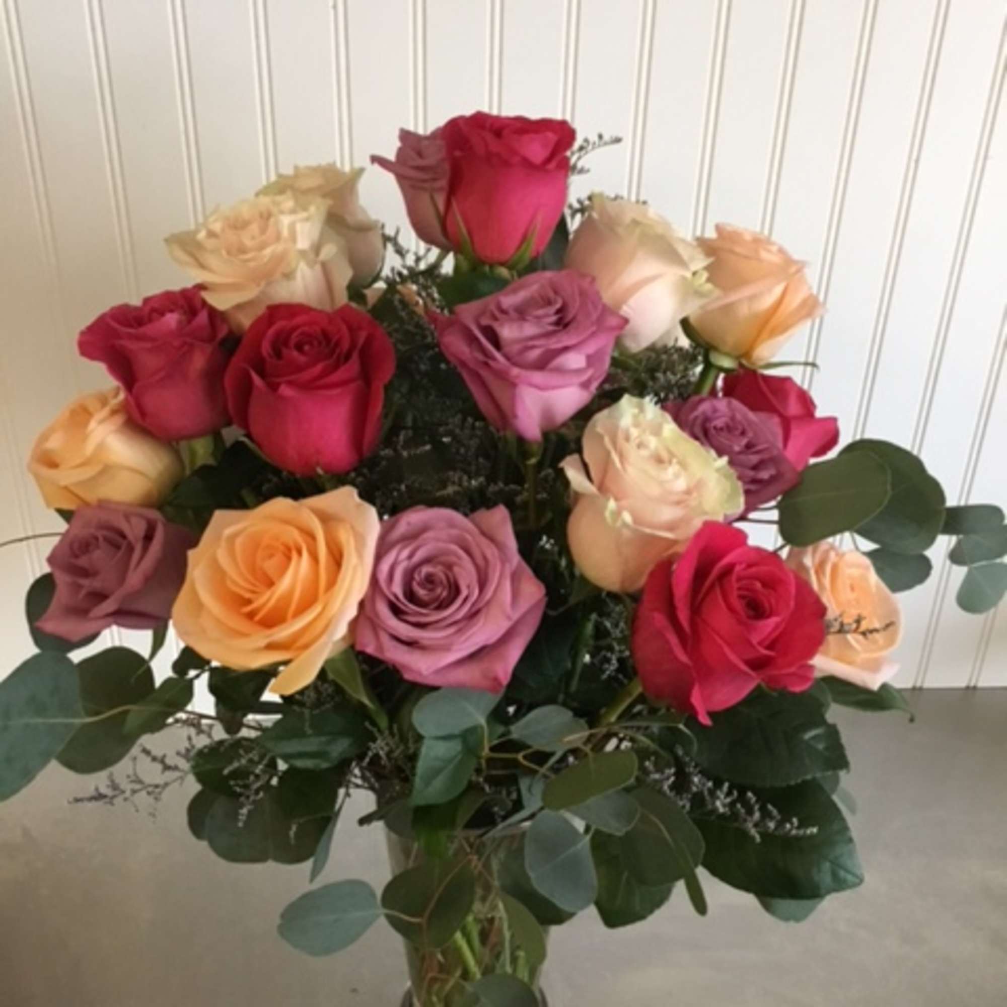 Bouquet of multicolored roses in a clear glass vase