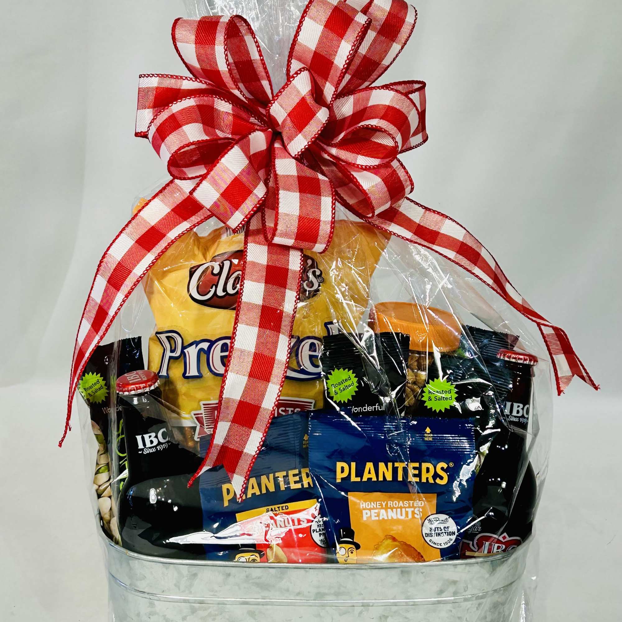 Gift basket of assorted snack bags wrapped with a red plaid bow